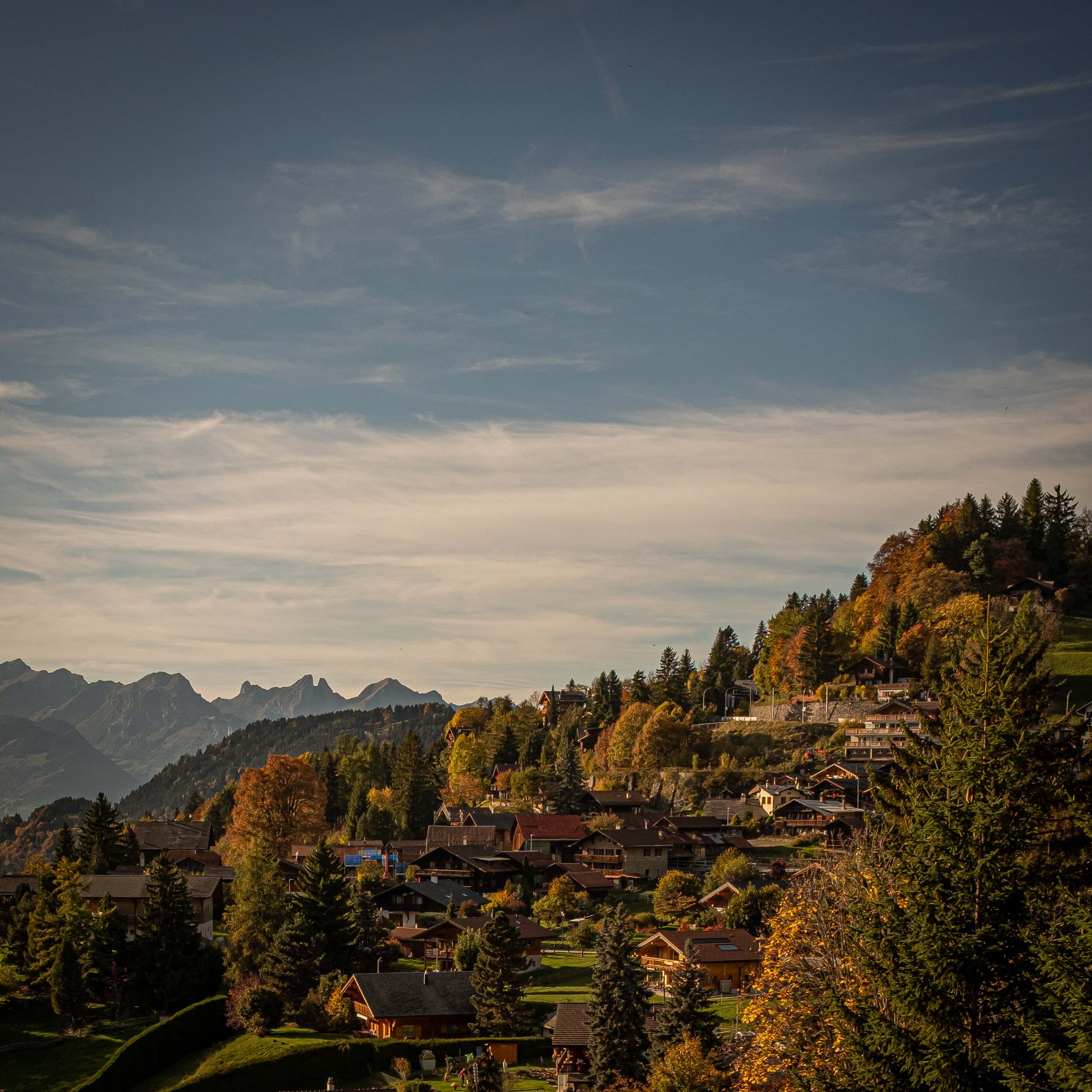 In the heart of the Swiss mountains, this village offers an exceptional panorama of the Alps. The wooden chalets, scattered on the green slopes, are surrounded by a forest with autumnal hues which enhance the landscape. The calm of this region, combined with the natural beauty of the mountains and forests, creates a warm and soothing atmosphere, inviting contemplation.