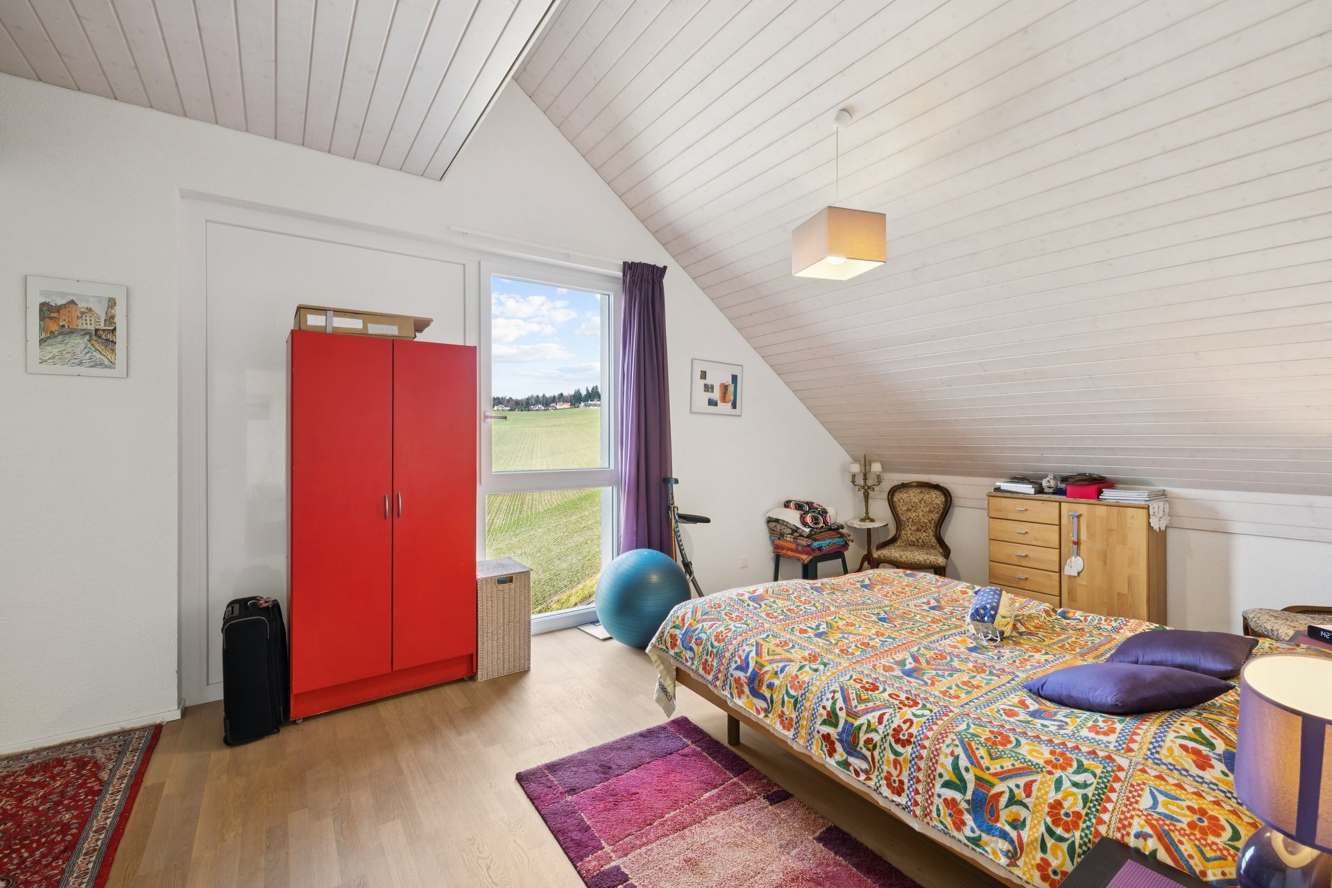 une chambre avec un grand lit et une grande fenêtre au plafond