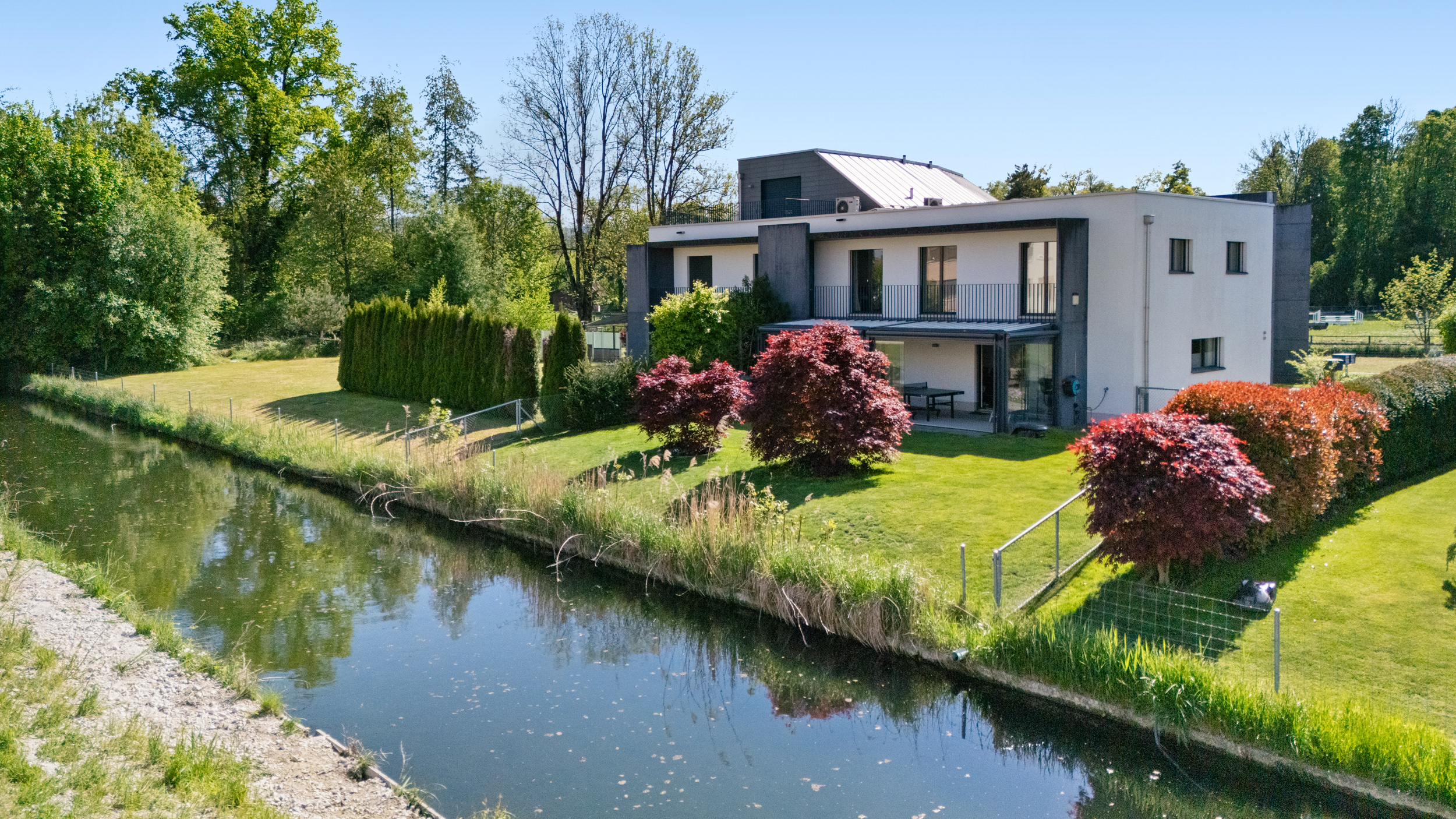 Wo Familienglück zu Hause ist: Modernes Haus mit Garten am Bach.