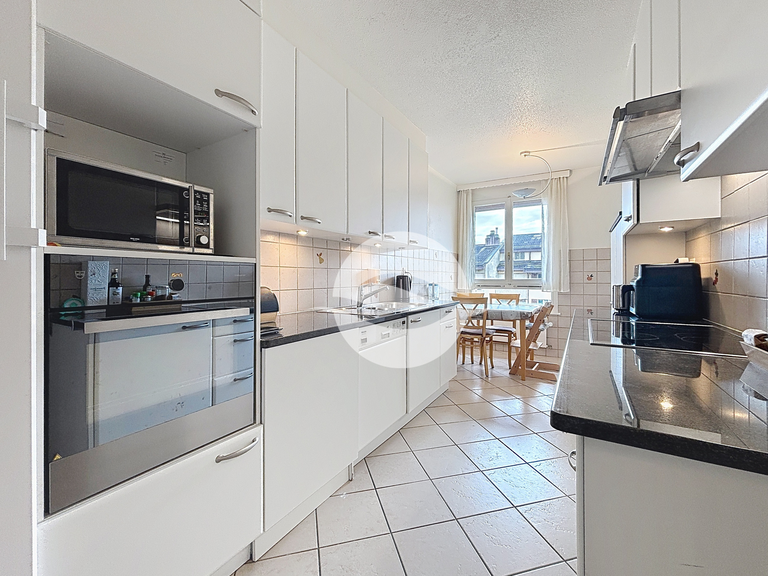 Cuisine semi-ouverte sur le séjour équipée ZUG et MIELE avec lave-linge et sèche-linge