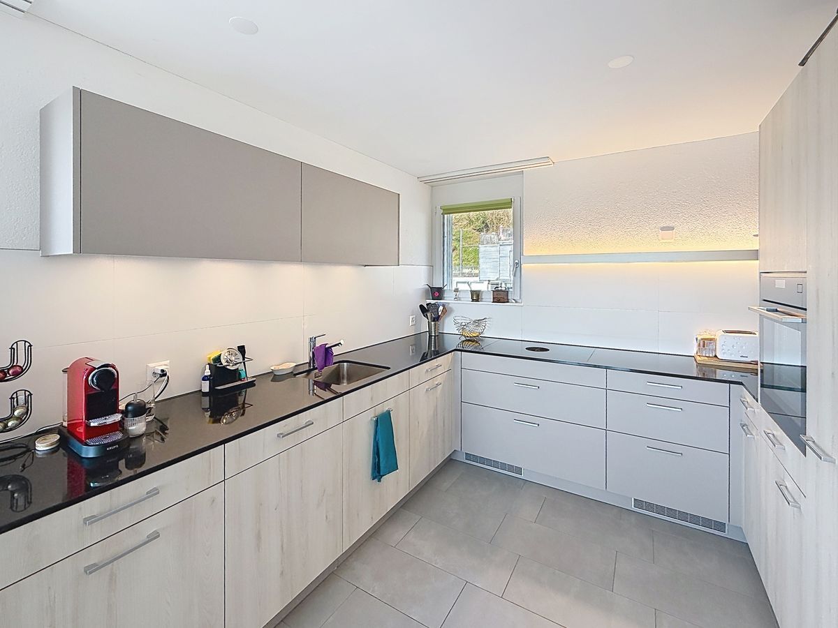 Cuisine équipée avec plan de travail et armoires modernes.