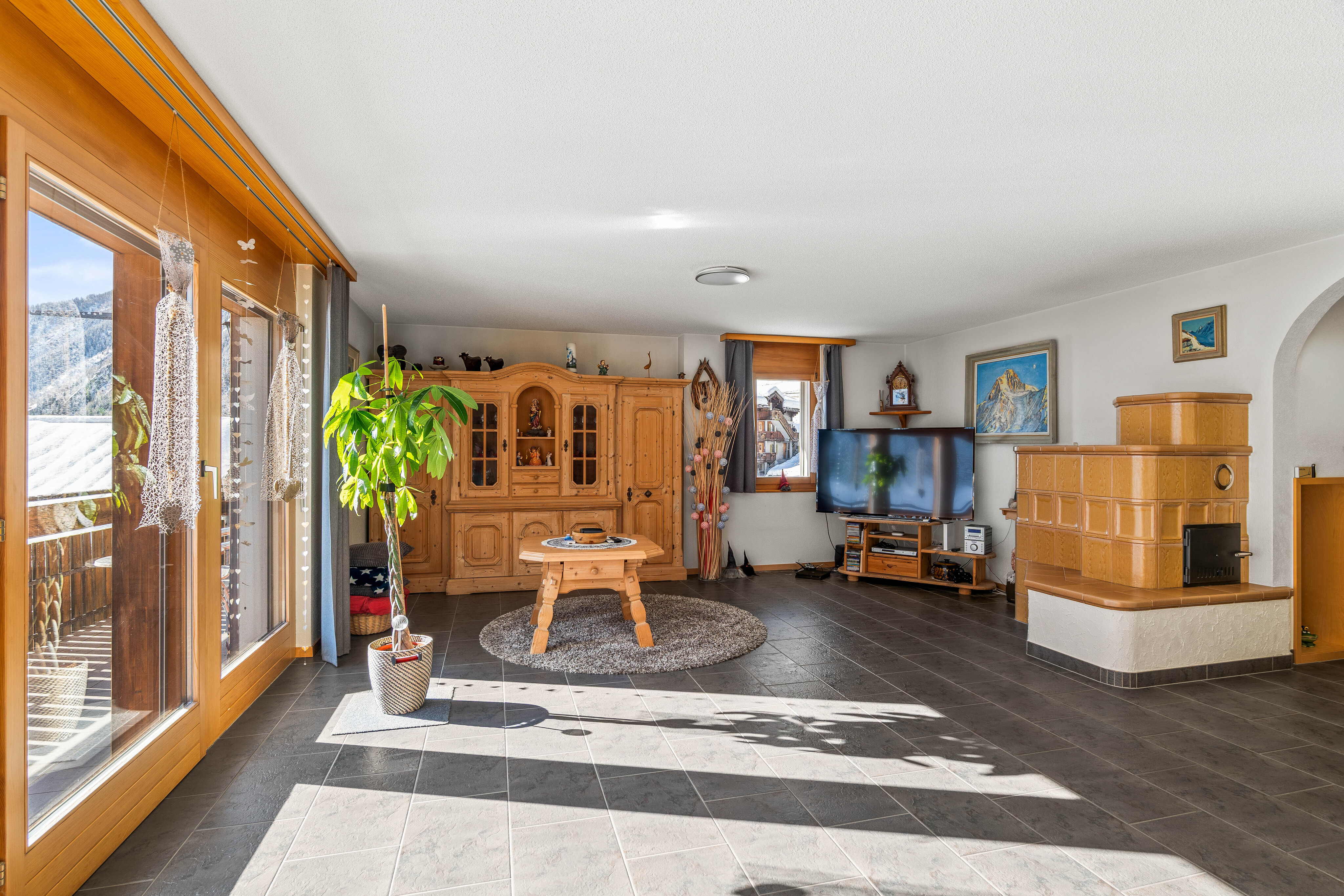 Ein rustikaler Kachelofen sorgt für eine behagliche Atmosphäre und ermöglicht es, das untere Geschoss auch ohne Aktivierung der Bodenheizung angenehm zu temperieren. Ein rustikaler Kachelofen sorgt für eine behagliche Atmosphäre und ermöglicht es, das untere Geschoss auch ohne Aktivierung der Bodenheizung angenehm zu temperieren.