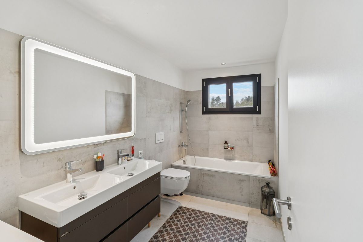 Salle de bain moderne avec double vasque et baignoire.