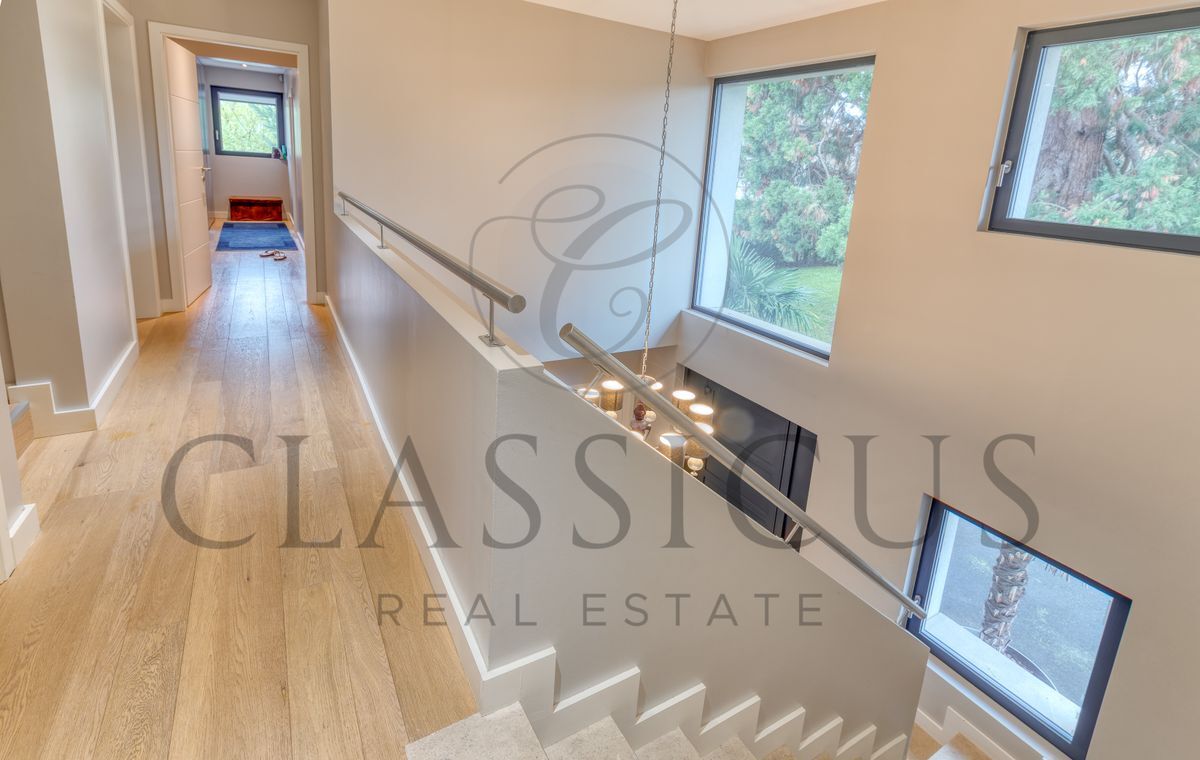 Lumineux couloir avec parquet et vue extérieure.