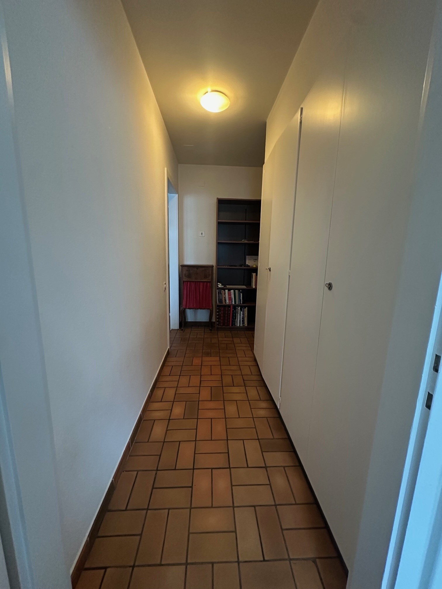 a hallway with a door leading to another room in an apartment