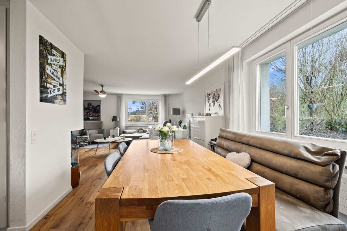 Eleganter Essbereich mit Holzdetails und großen Fenstern.