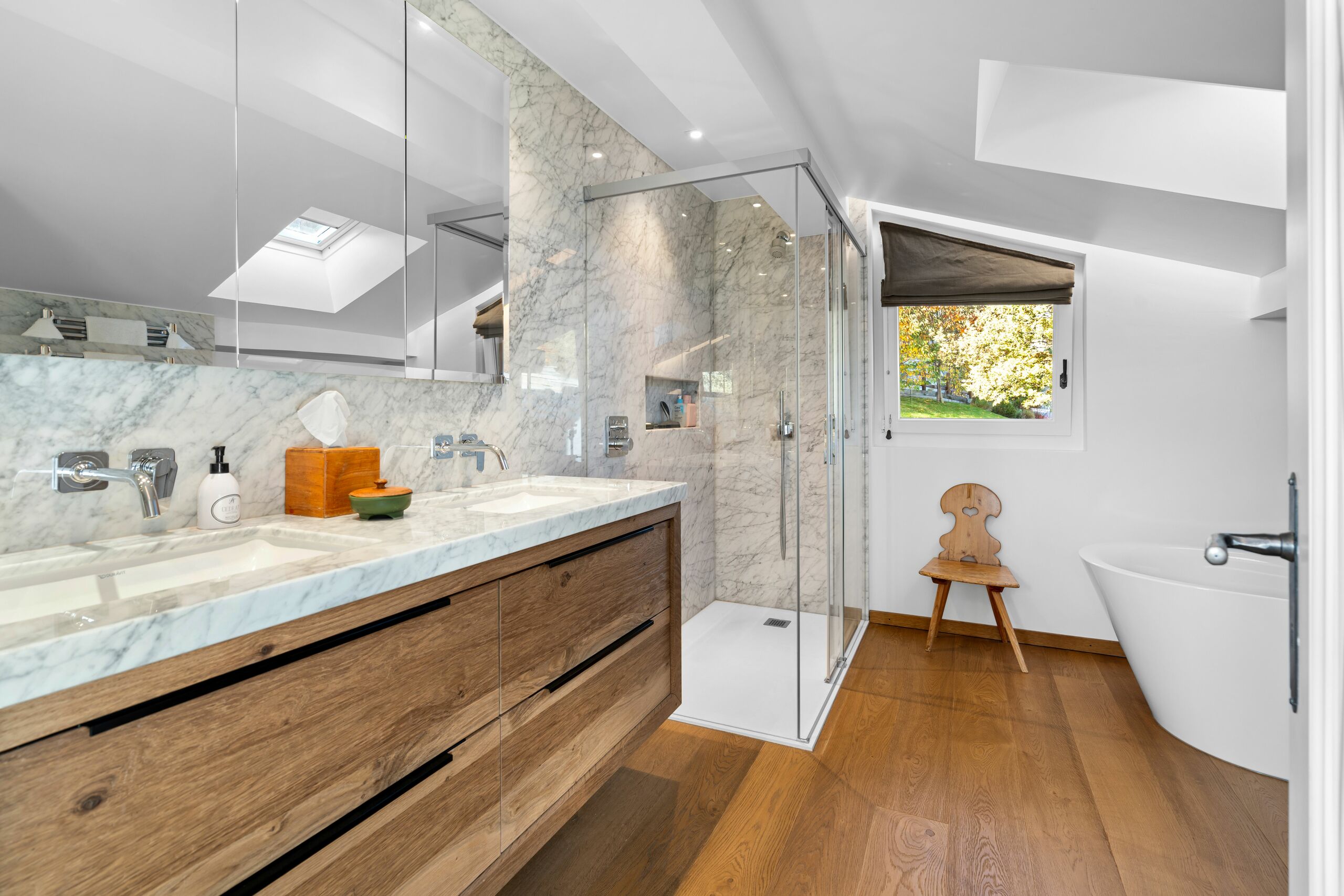 a modern bathroom with a large tub and sink under a skylight