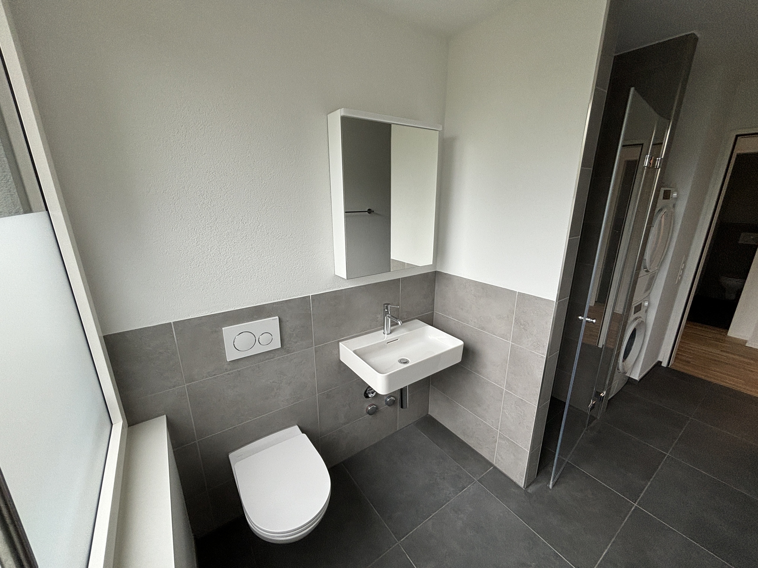 Eines der Badezimmer mit Dusche, Toilette, Lavabo und Waschturm