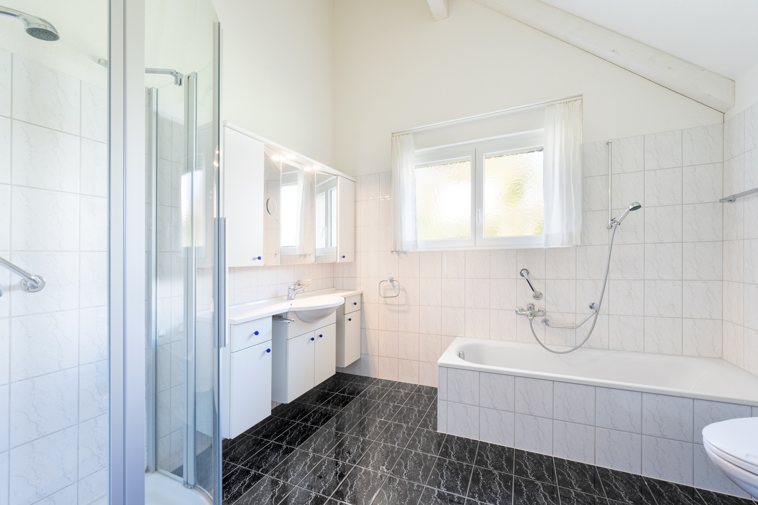 Nasszelle mit Badewanne und Dusche im Dachgeschoss