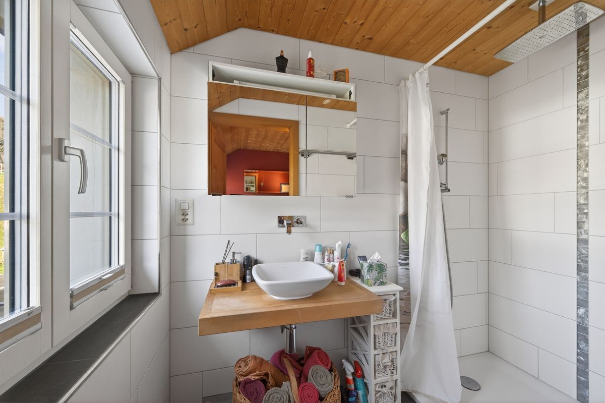 Modernes Badezimmer mit Duschbereich im Obergeschoss.