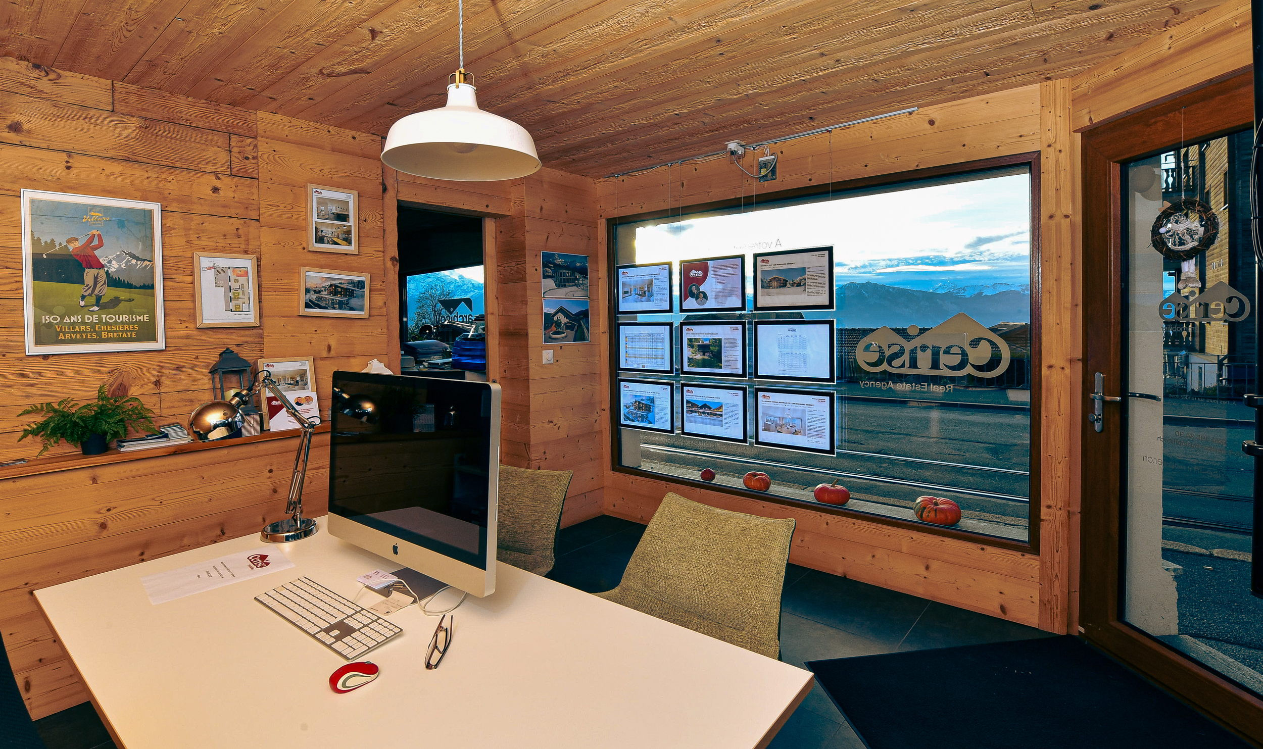 L'intérieur chaleureux et accueillant du bureau de Cerise Immobilier, avec des murs en bois naturel. Un espace propice aux échanges, offrant une vue imprenable sur les montagnes, reflétant le caractère local et authentique de l'agence.