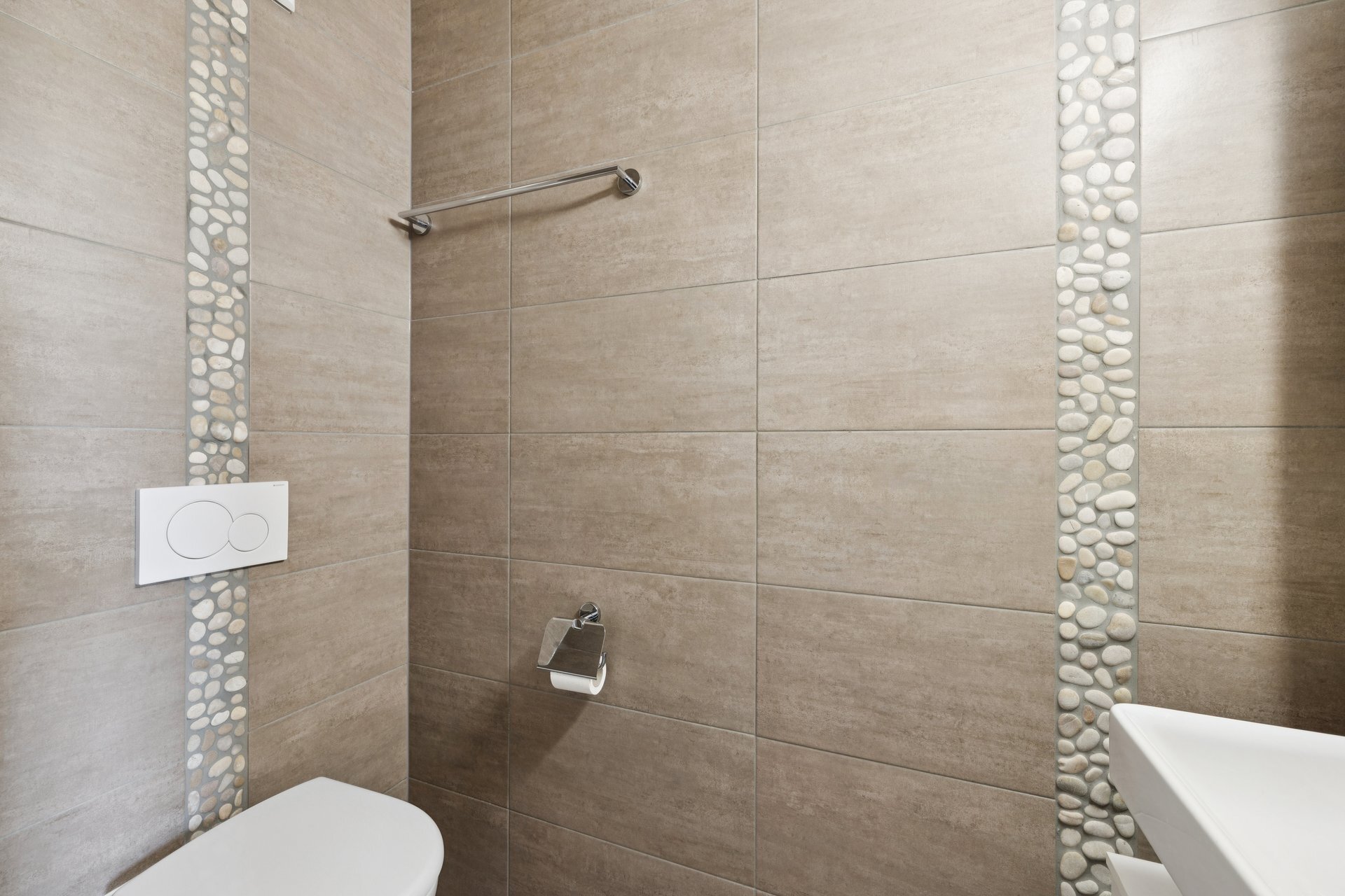 une salle de bains avec des toilettes blanches et une douche à l'italienne