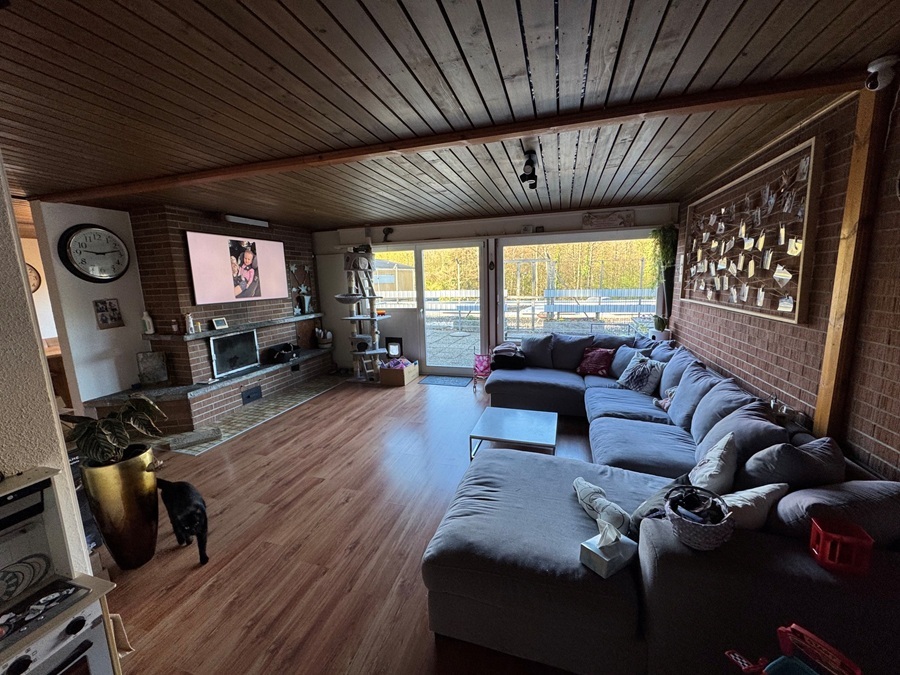 Wohnzimmer mit Cheminée und Austritt auf grosse Dachterrasse