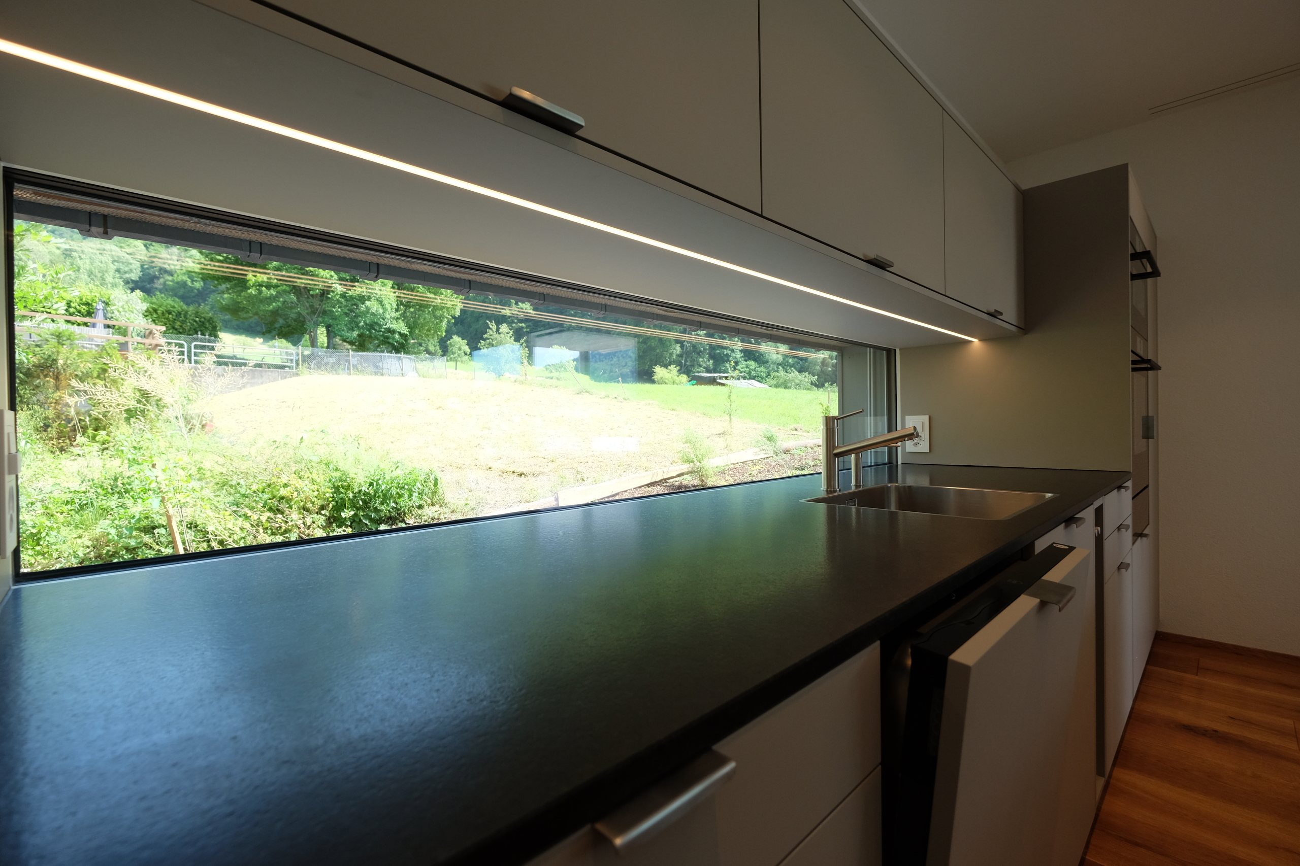 Küche mit Glasfenster ins Grüne Küche mit Glasfenster ins Grüne