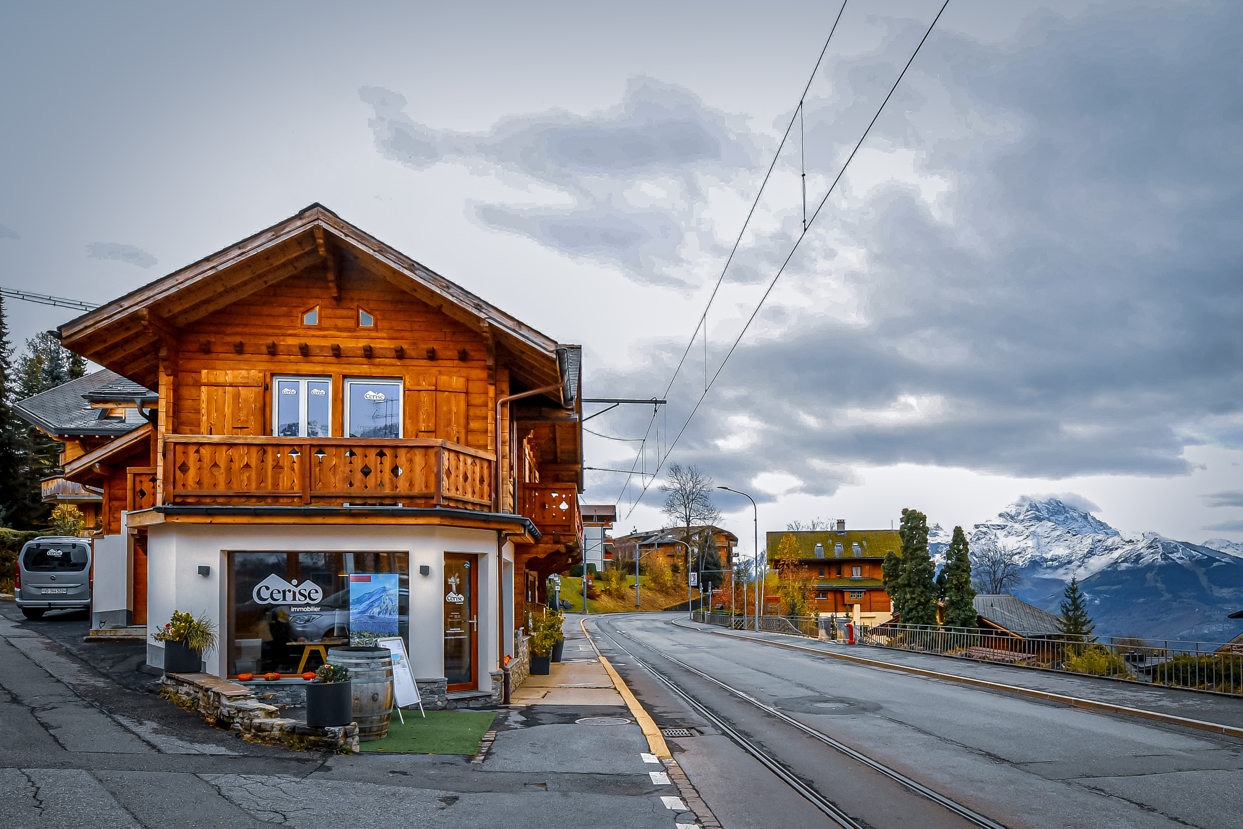 L'entrée des bureaux de Cerise Immobilier à Villars-sur-Ollon, avec une ambiance accueillante et locale. Les grandes fenêtres laissent entrevoir l'intérieur chaleureux de l'agence, reflétant l'authenticité de la région alpine.