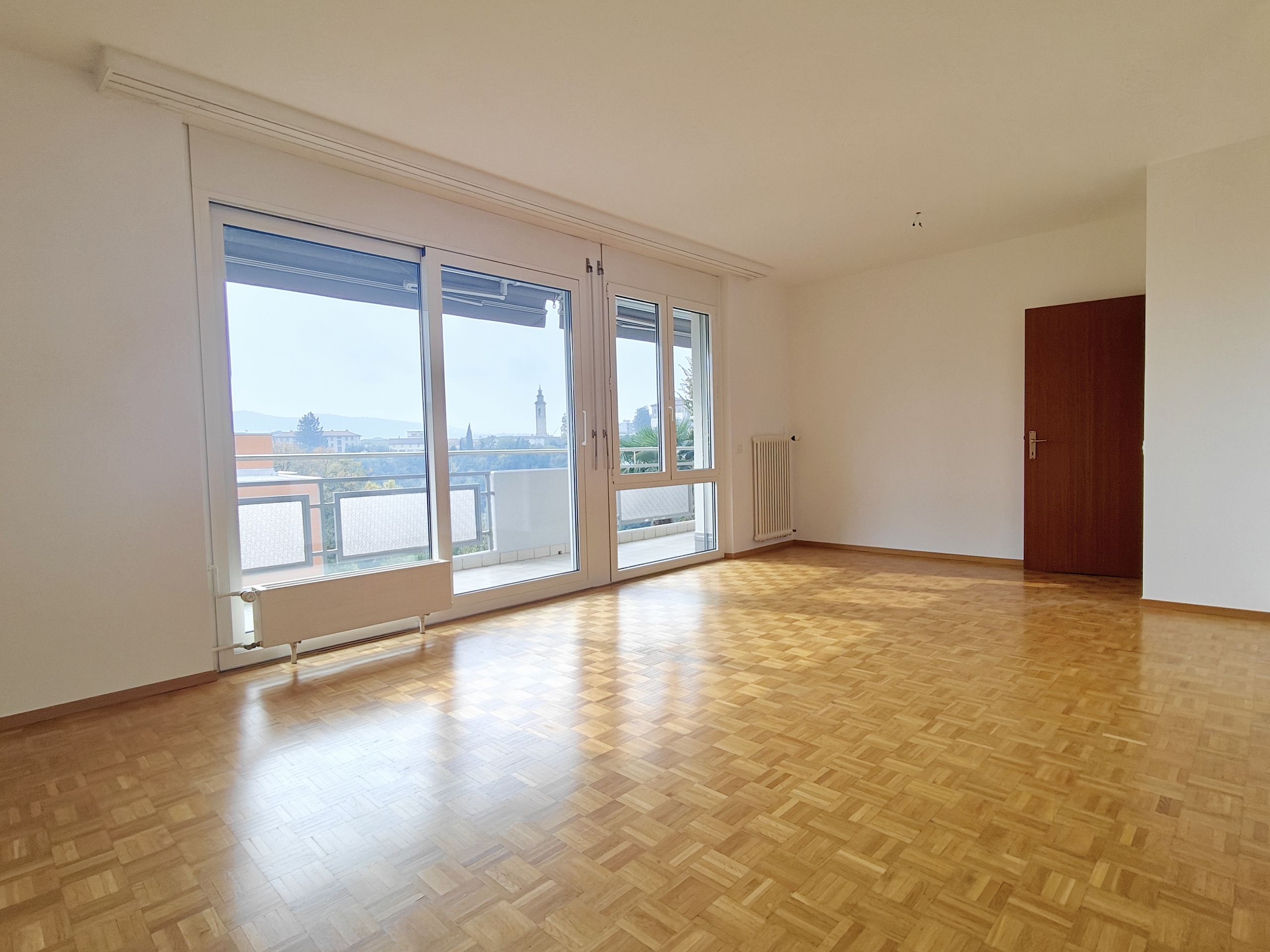 an empty room with wooden floors and large windows an empty room with wooden floors and large windows