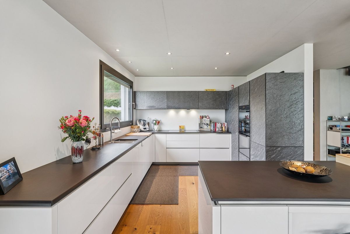 Cuisine moderne avec grandes fenêtres et îlot central.