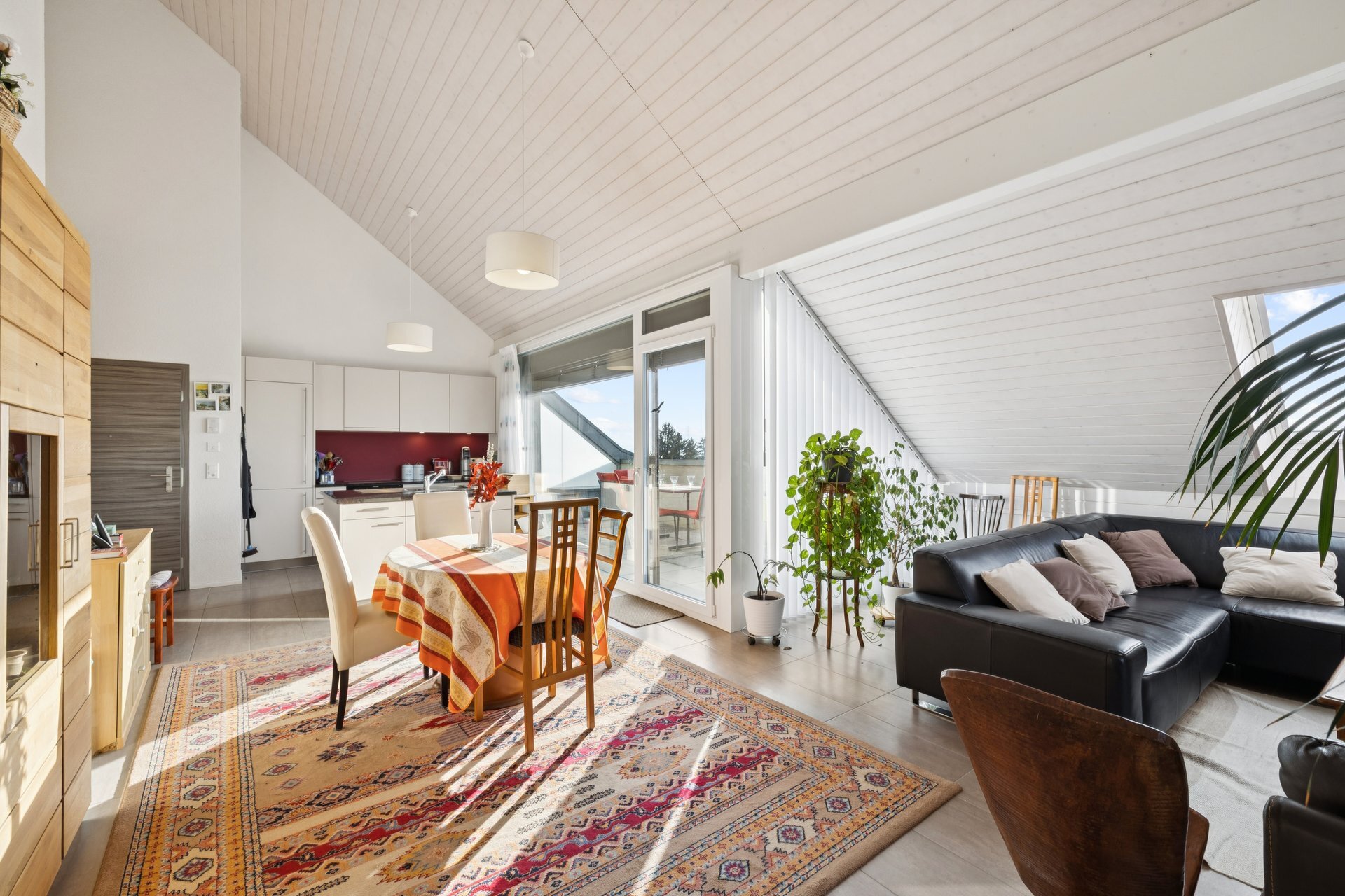 une grande pièce avec une table et des chaises, un salon et une salle à manger avec vue sur la cuisine