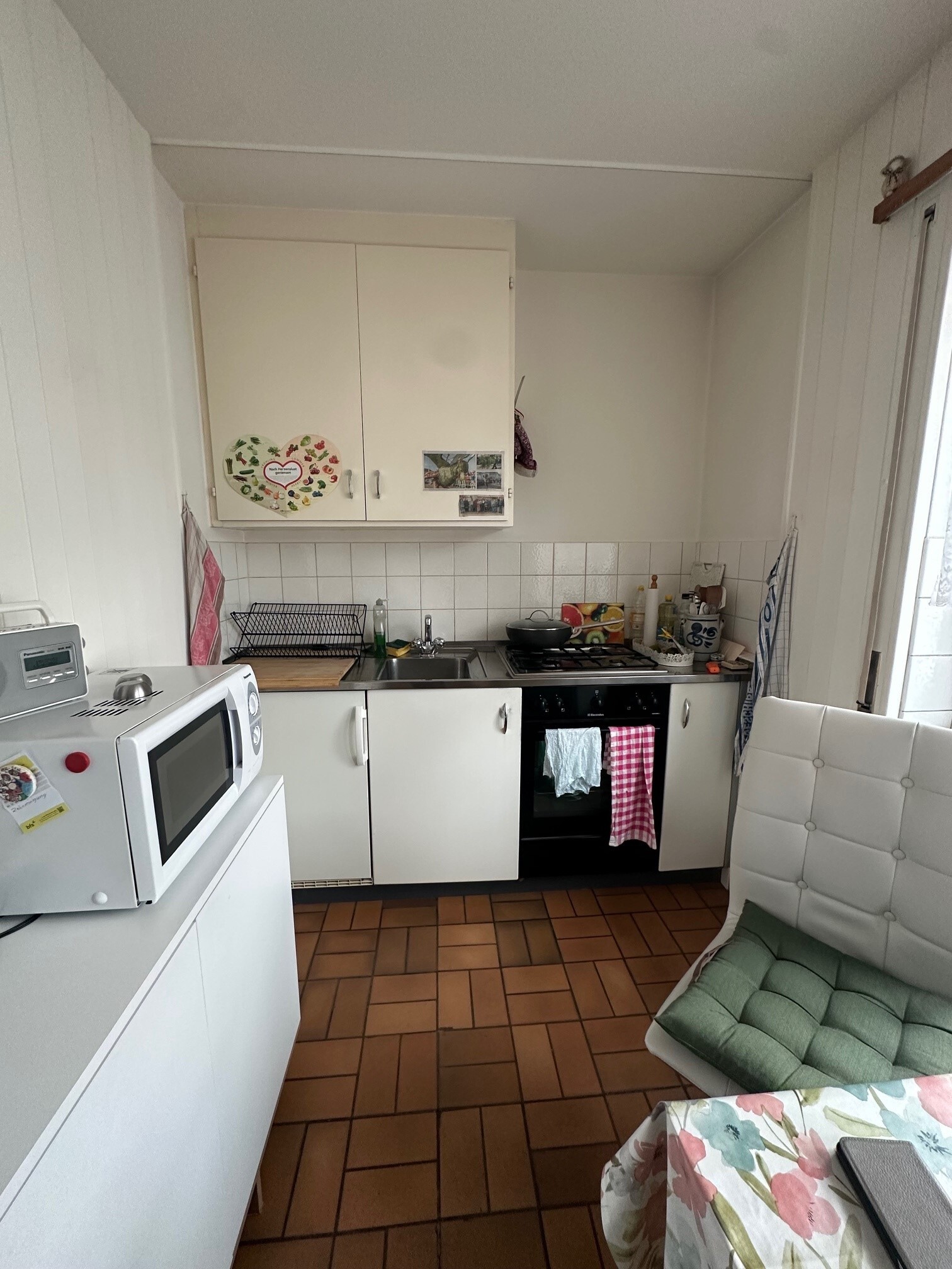 a small kitchen with white appliances and a stove and microwave