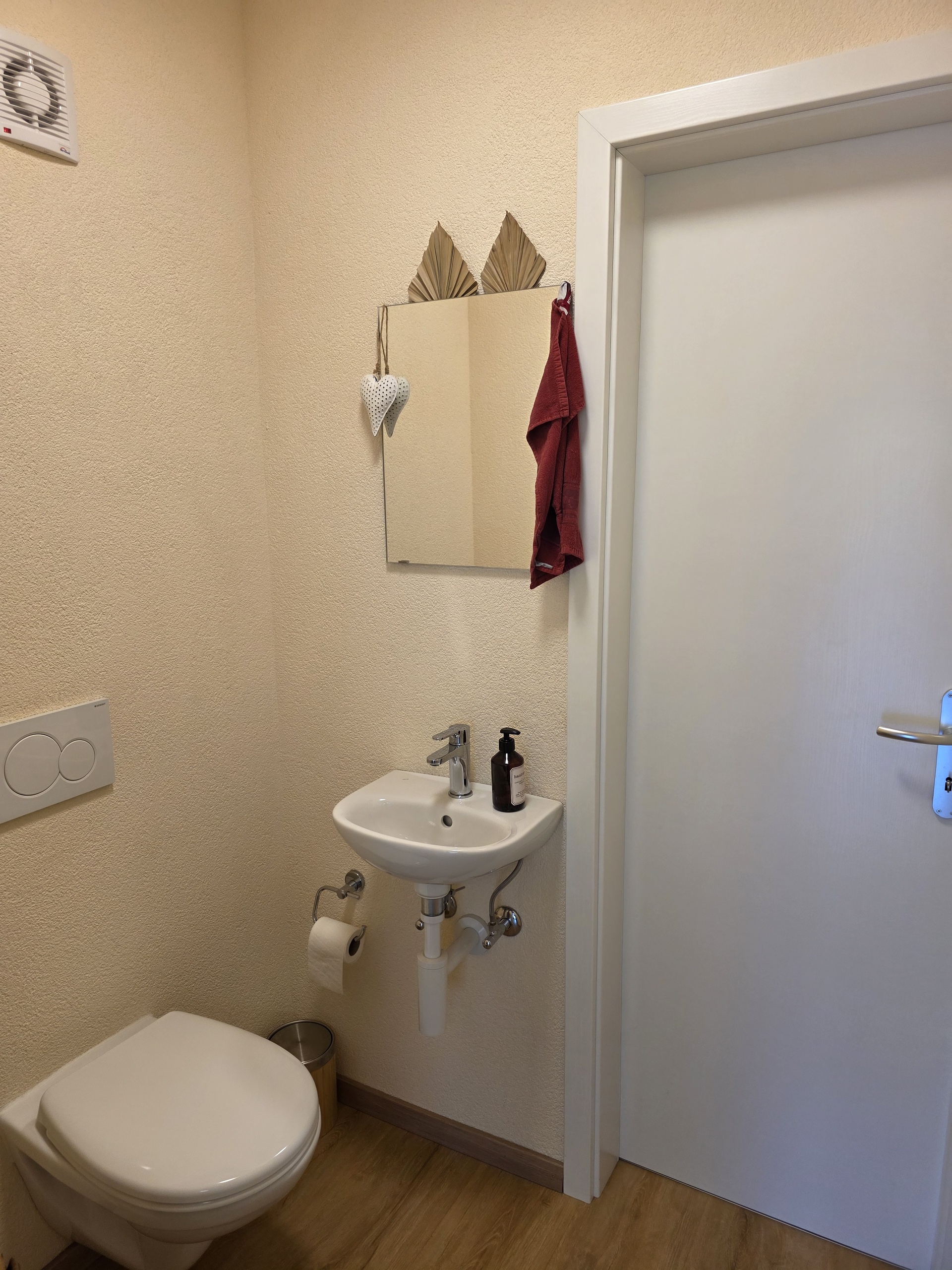 une petite salle de bains avec des toilettes, un lavabo et un miroir fixé au mur une petite salle de bains avec des toilettes, un lavabo et un miroir fixé au mur
