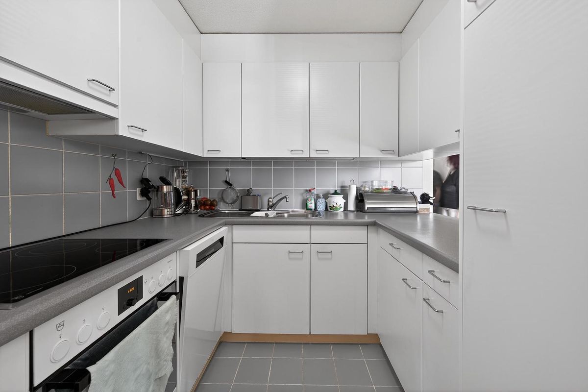 Moderne Küche mit eleganten Schränken und integrierten Geräten.