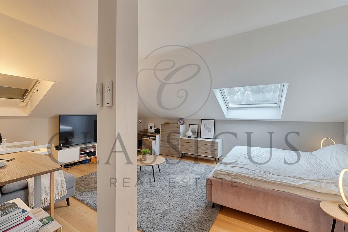 Chambre avec lucarne et espace de travail moderne.