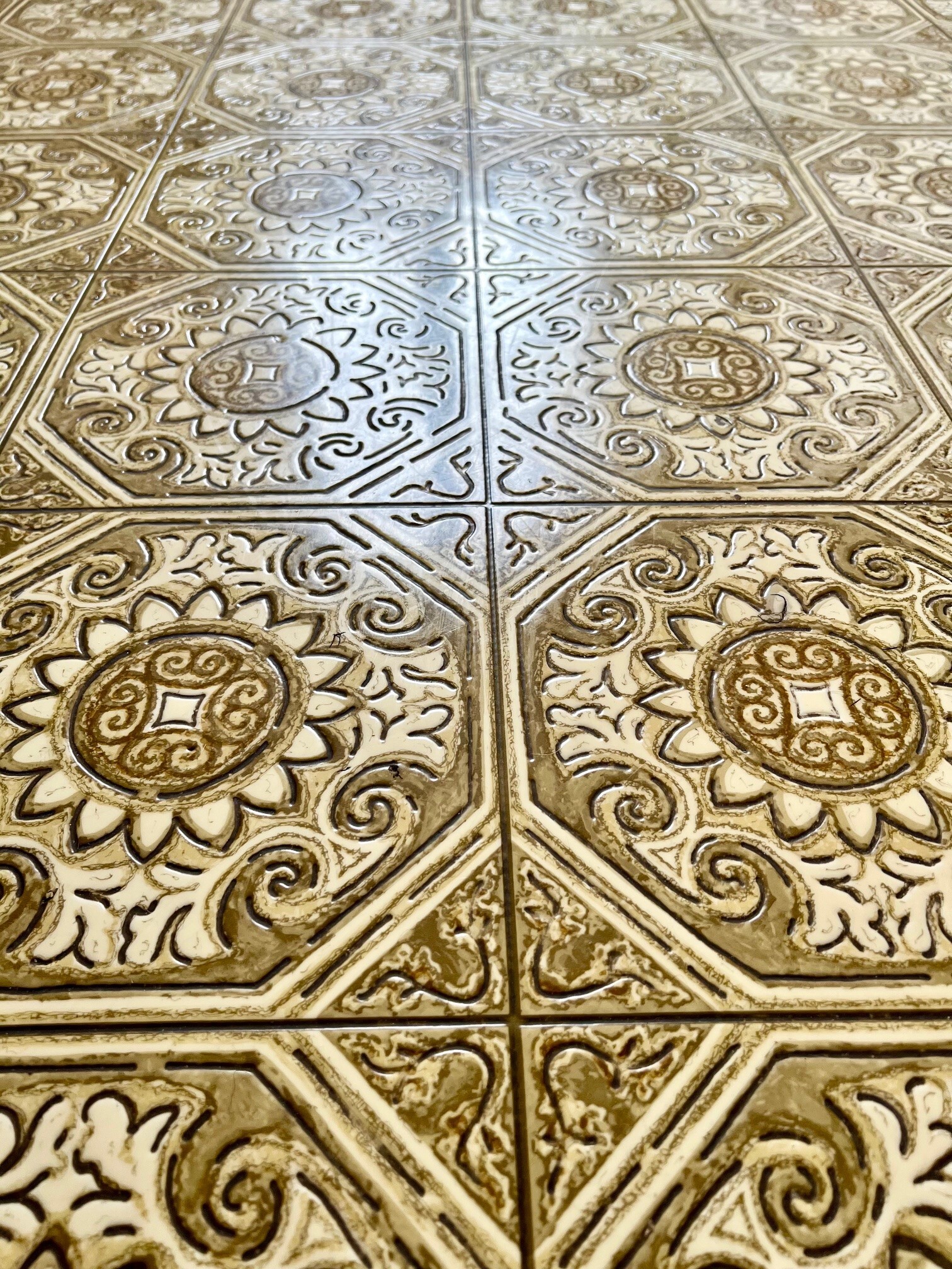 a floor with intricate designs on the tiles