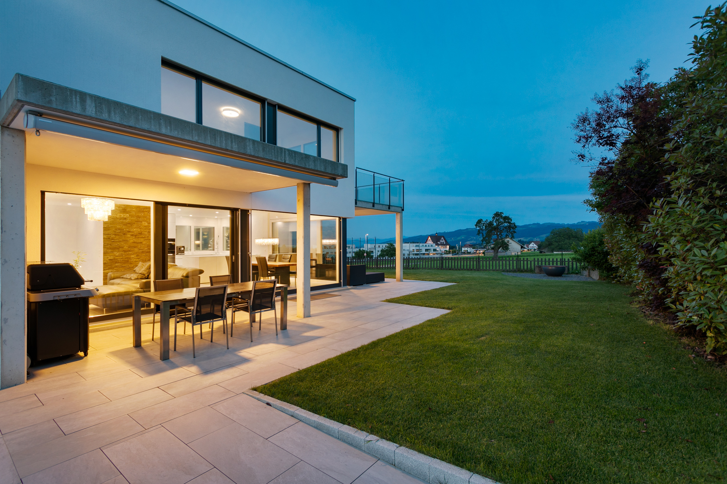 Grosszügiger smarter Gartenbereich mit Feuerstelle für gesellige Abende.