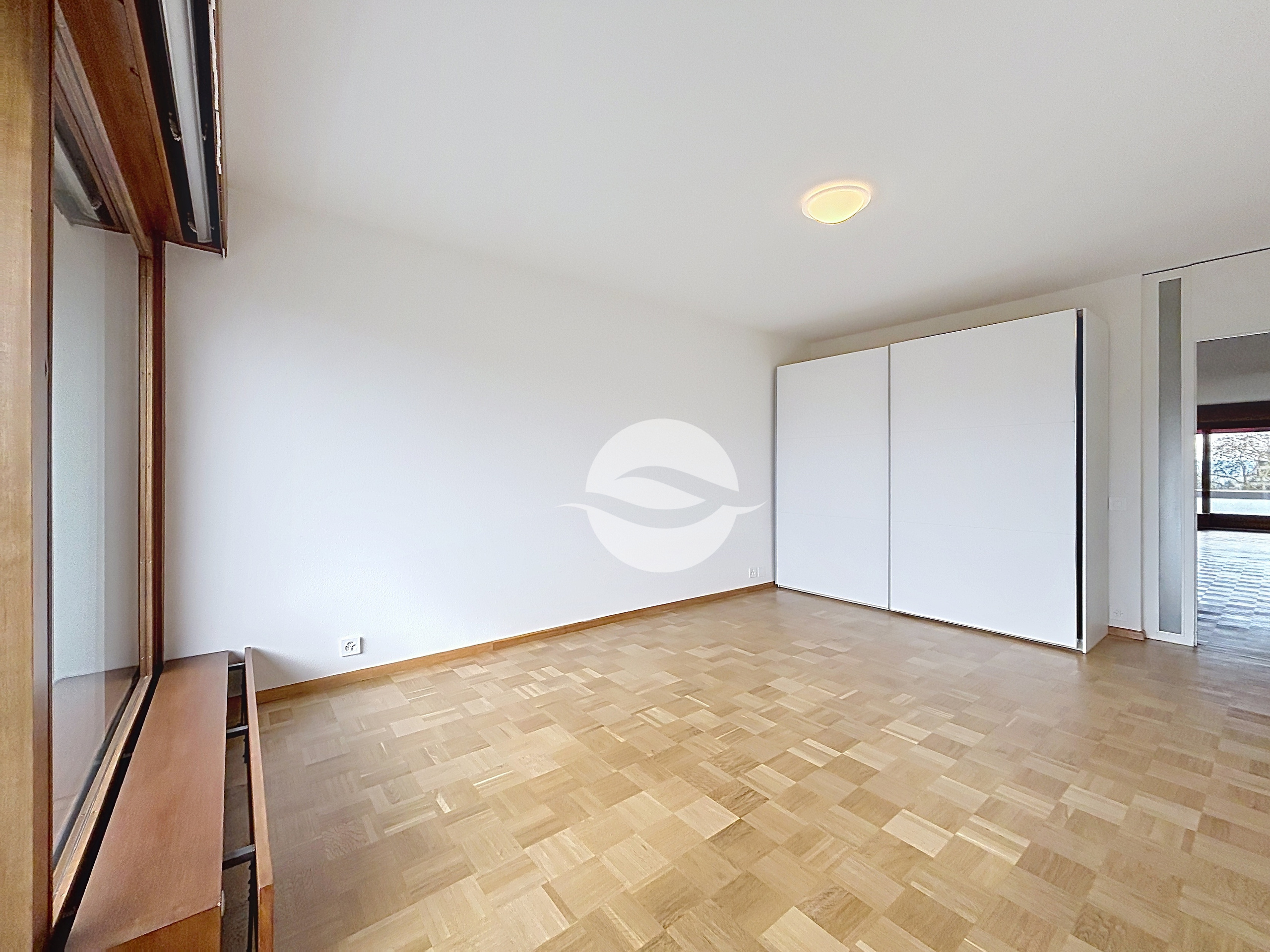 Chambre à coucher avec armoires accès balcon côté Jura