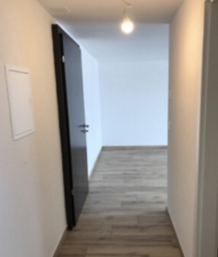 un couloir vide avec une porte blanche et un sol carrelé un couloir vide avec une porte blanche et un sol carrelé