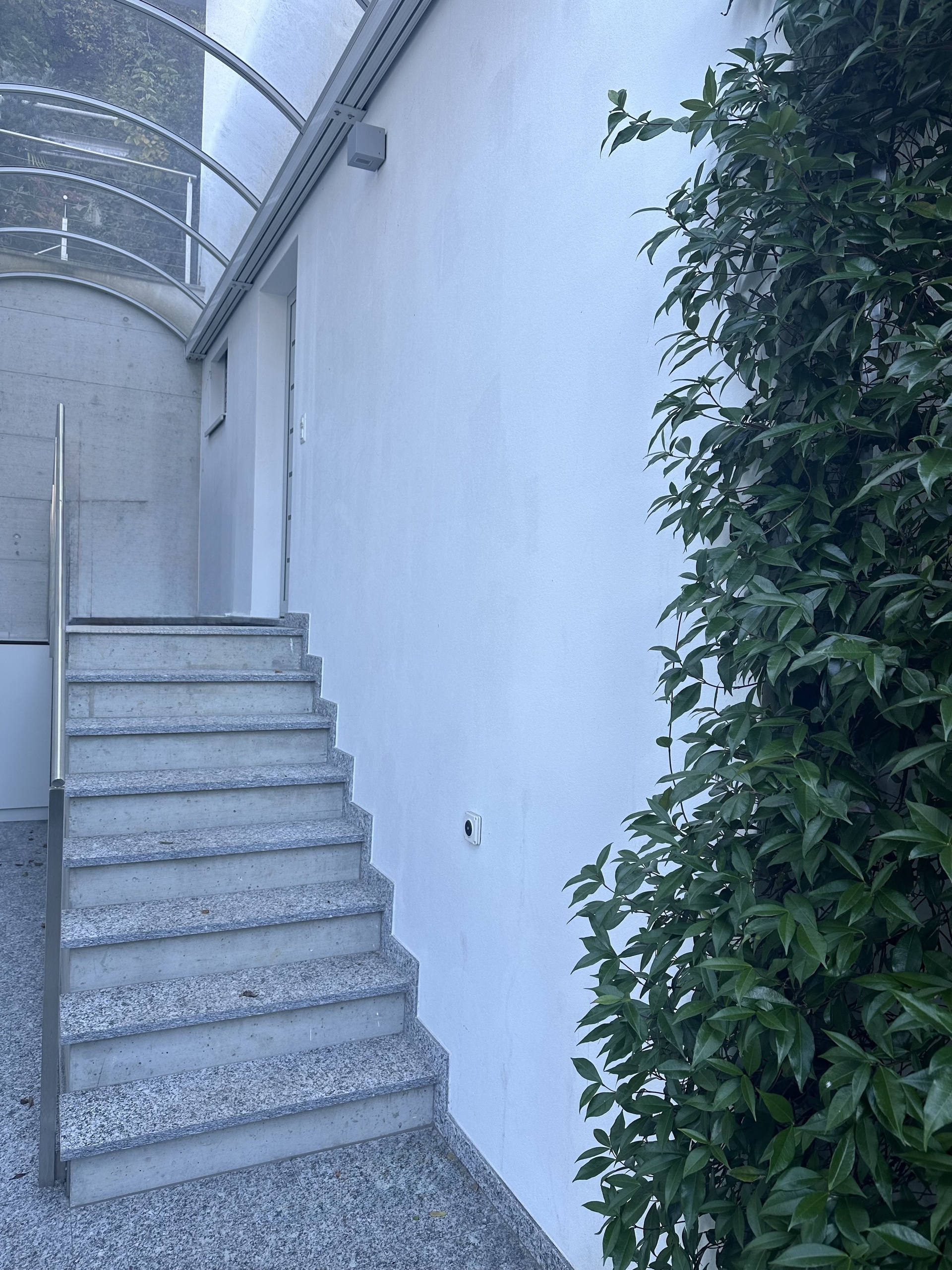 Der Weg vom Lift über eine Treppe zum Eingang der Immobilie.