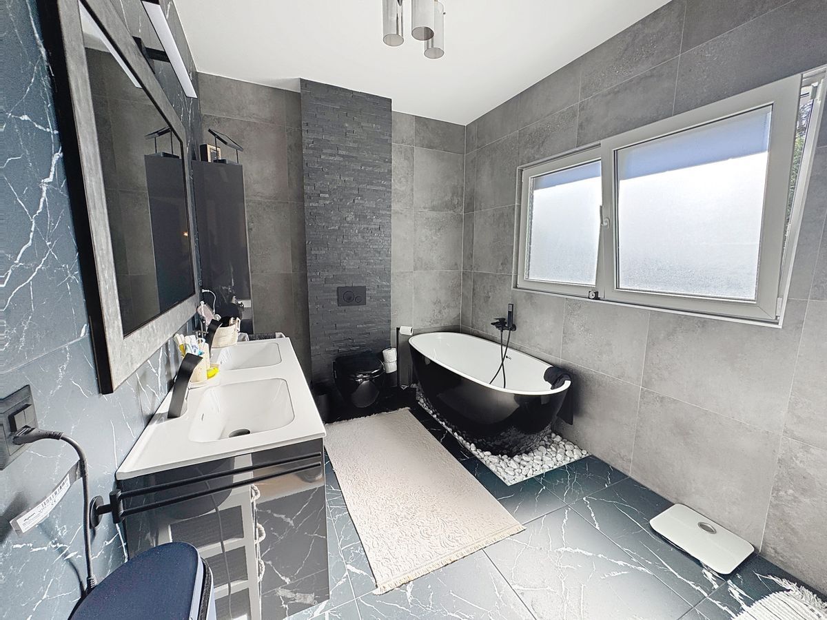 Salle de bains moderne avec baignoire et double vasque.