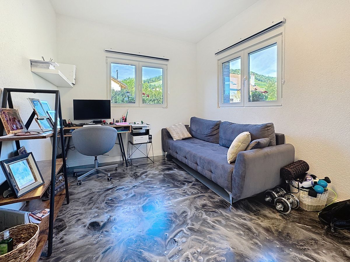 Bureau lumineux avec canapé et vue dégagée sur l'extérieur.