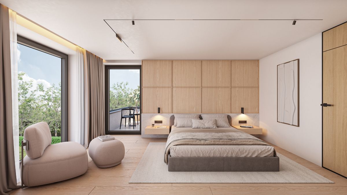 Une chambre avec lit double, fauteuil et balcon.