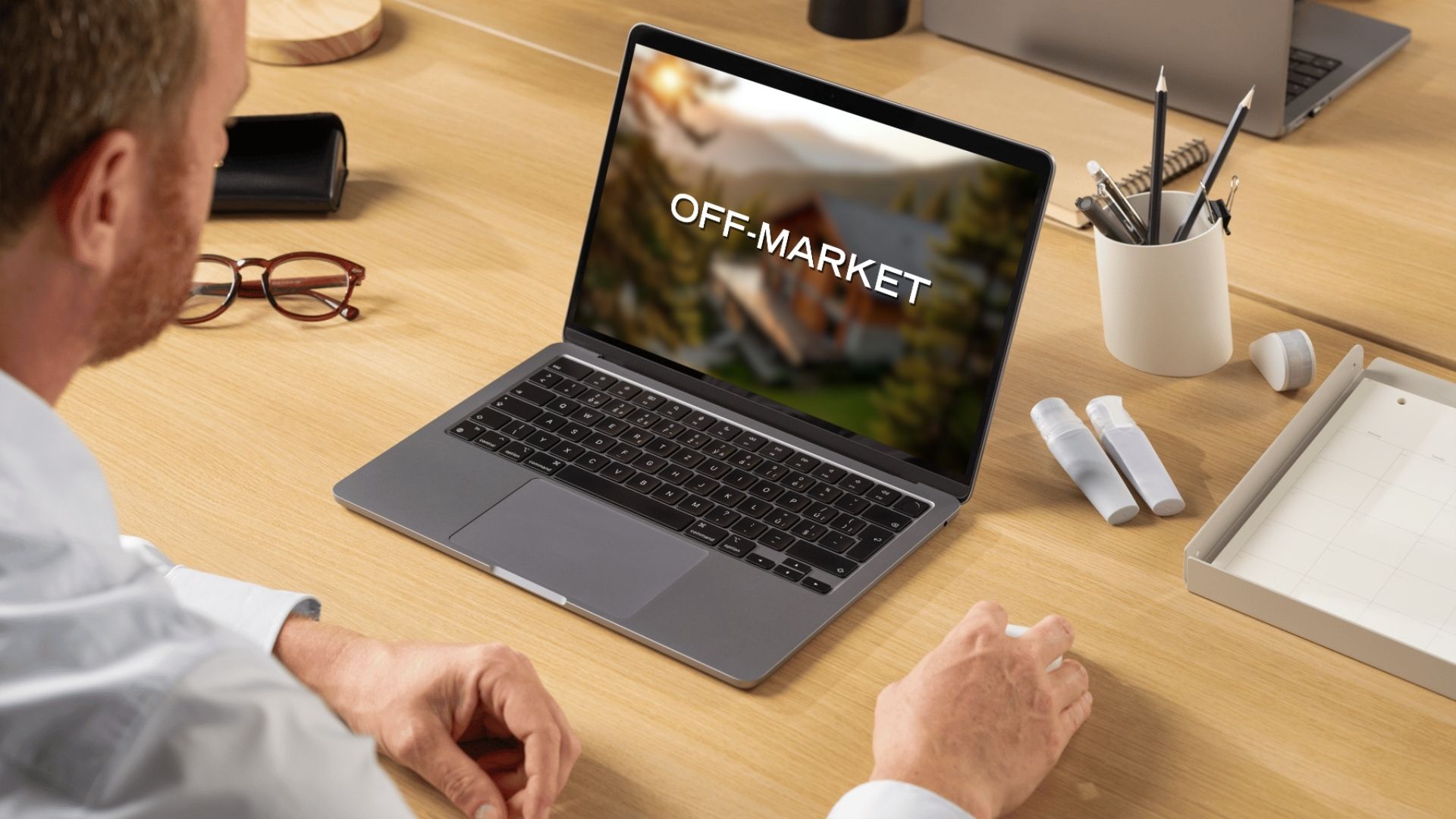 Real estate professional viewing an off-market property on a laptop, illustrating confidential real estate marketing in Switzerland.