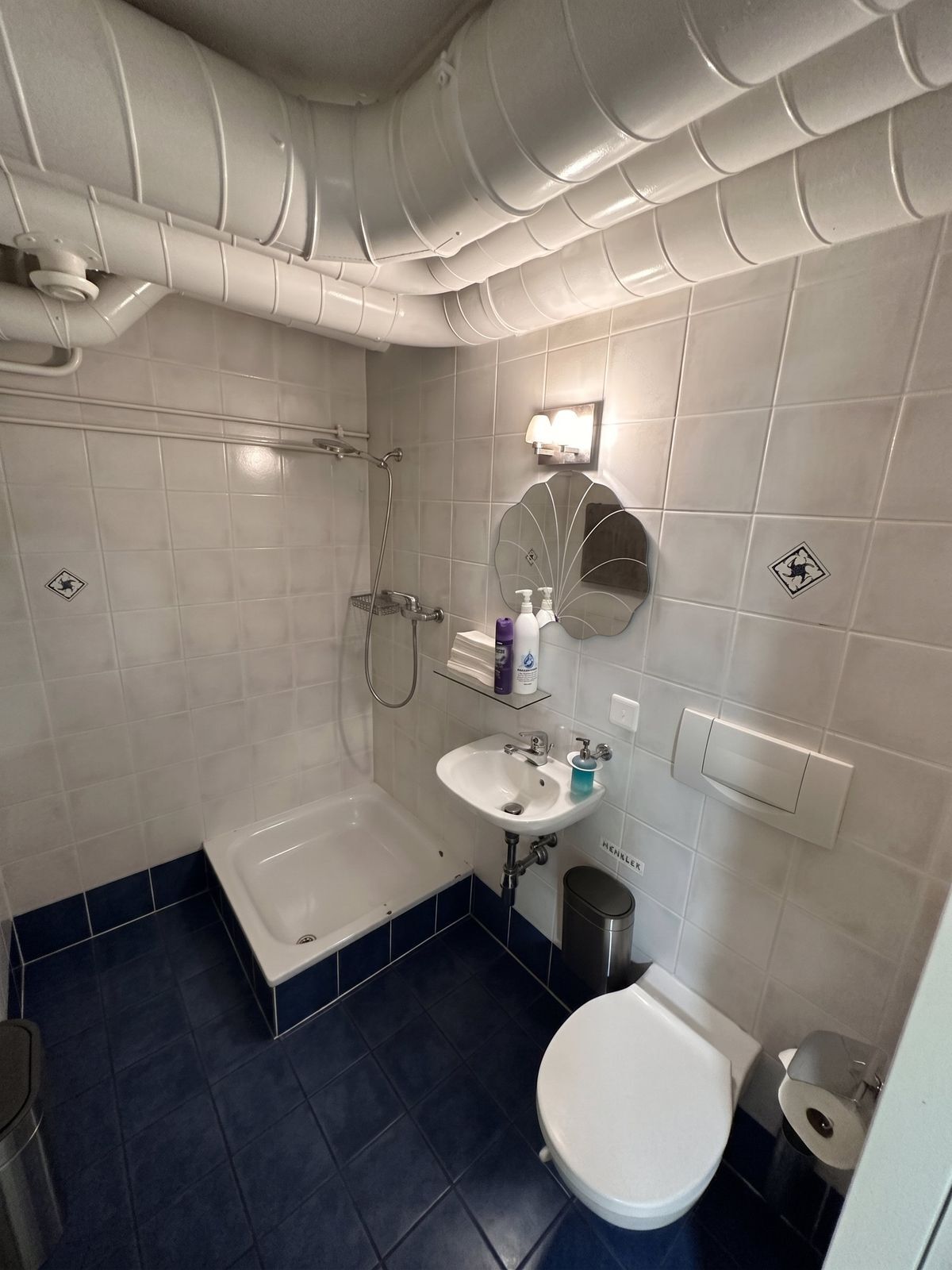 Salle de bain avec douche, lavabo et WC moderne.