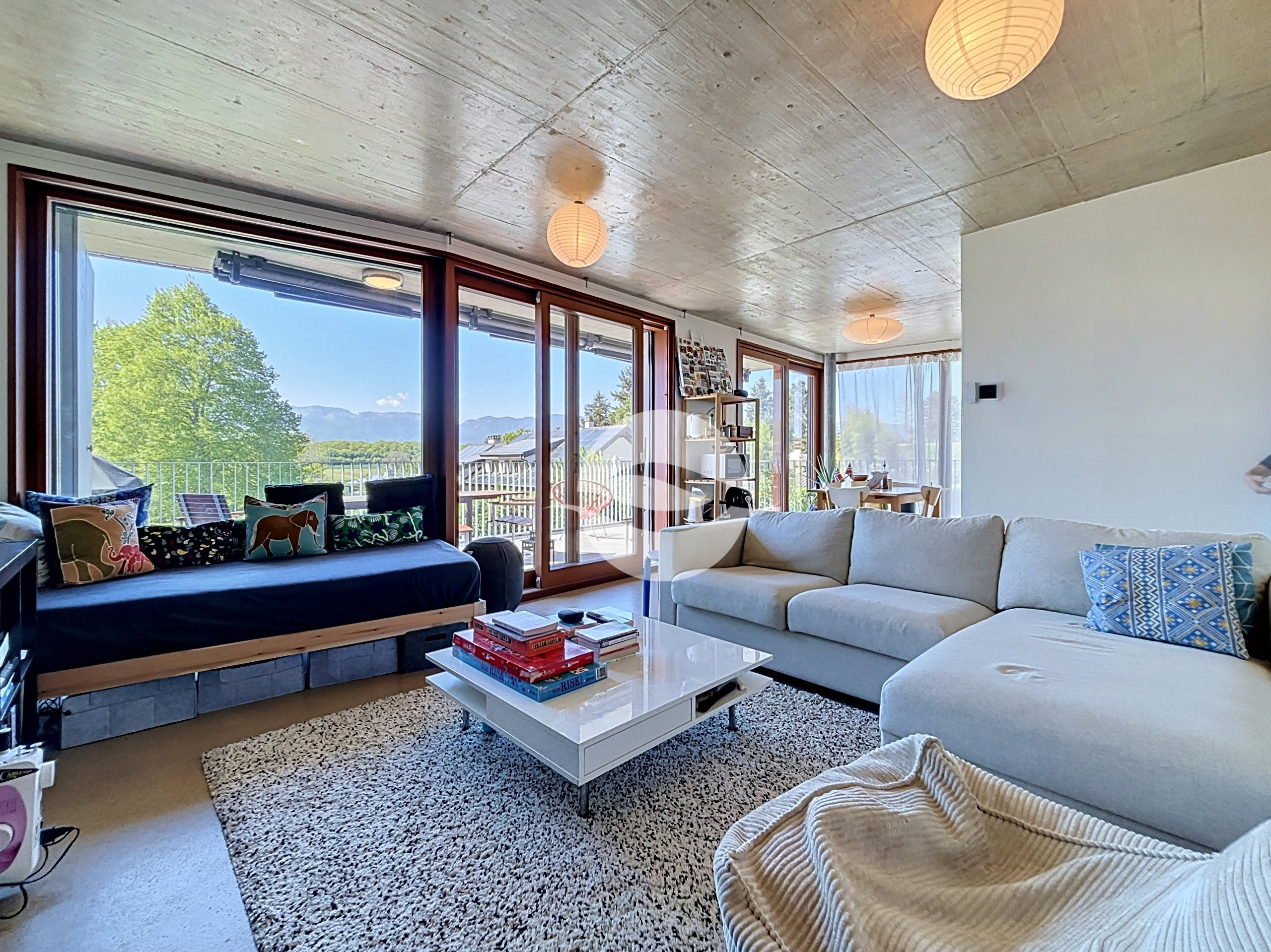 Spacieux séjour/salle à manger baigné de lumière grâce à de grandes baies vitrées, ouvrant sur une terrasse