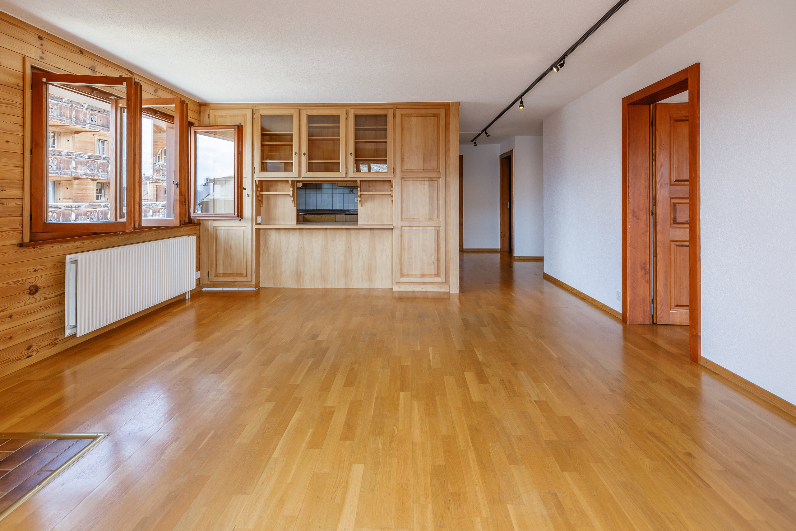 une pièce vide avec un sol en bois, des murs en bois et de grandes fenêtres