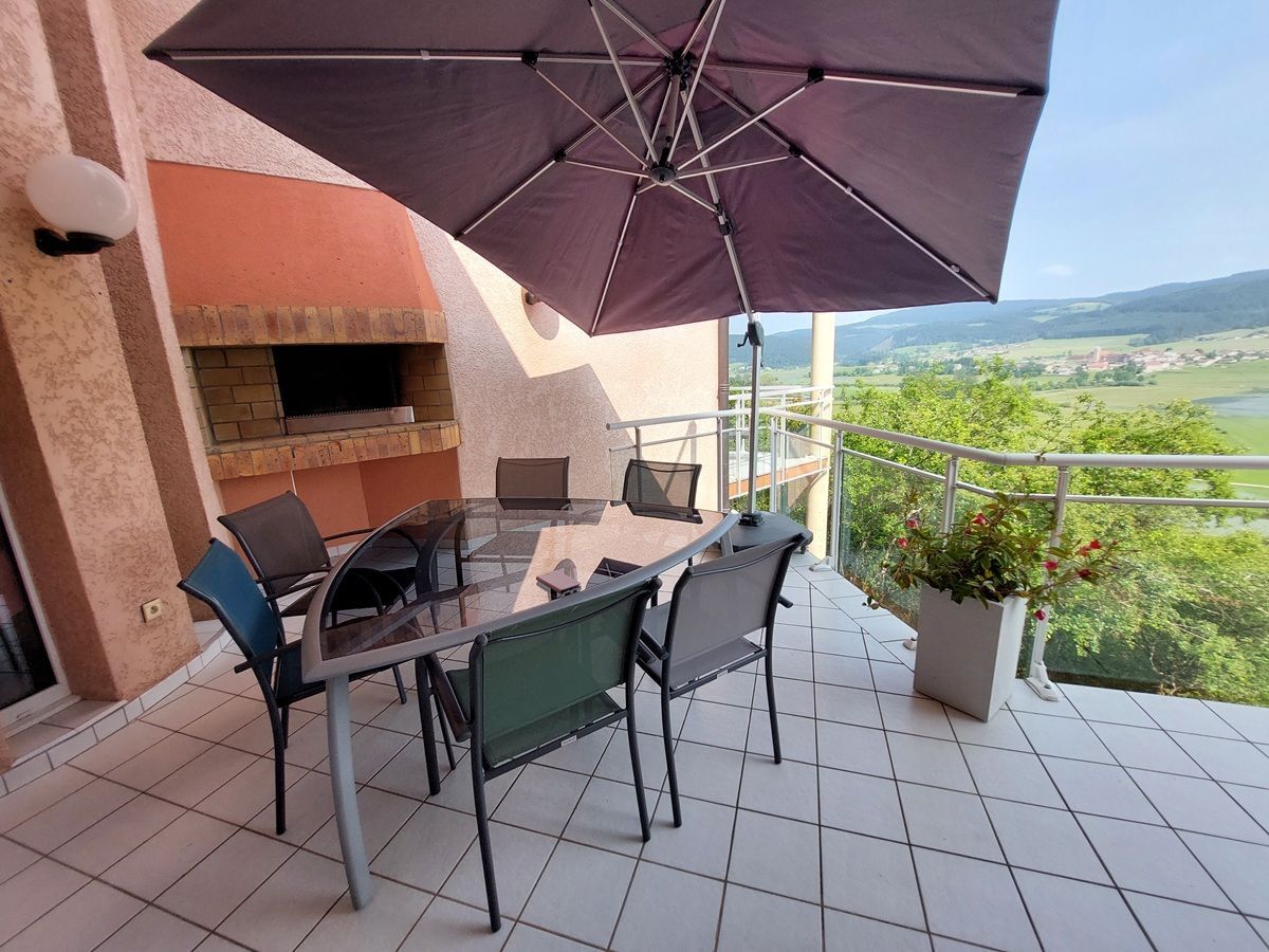 Terrasse avec vue panoramique et barbecue intégré.