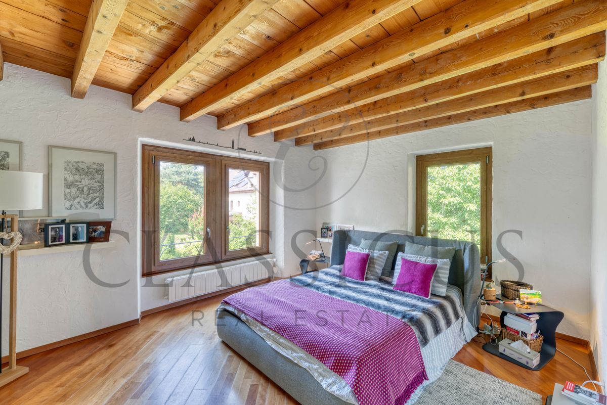 Chambre avec plafond en bois et grandes fenêtres.
