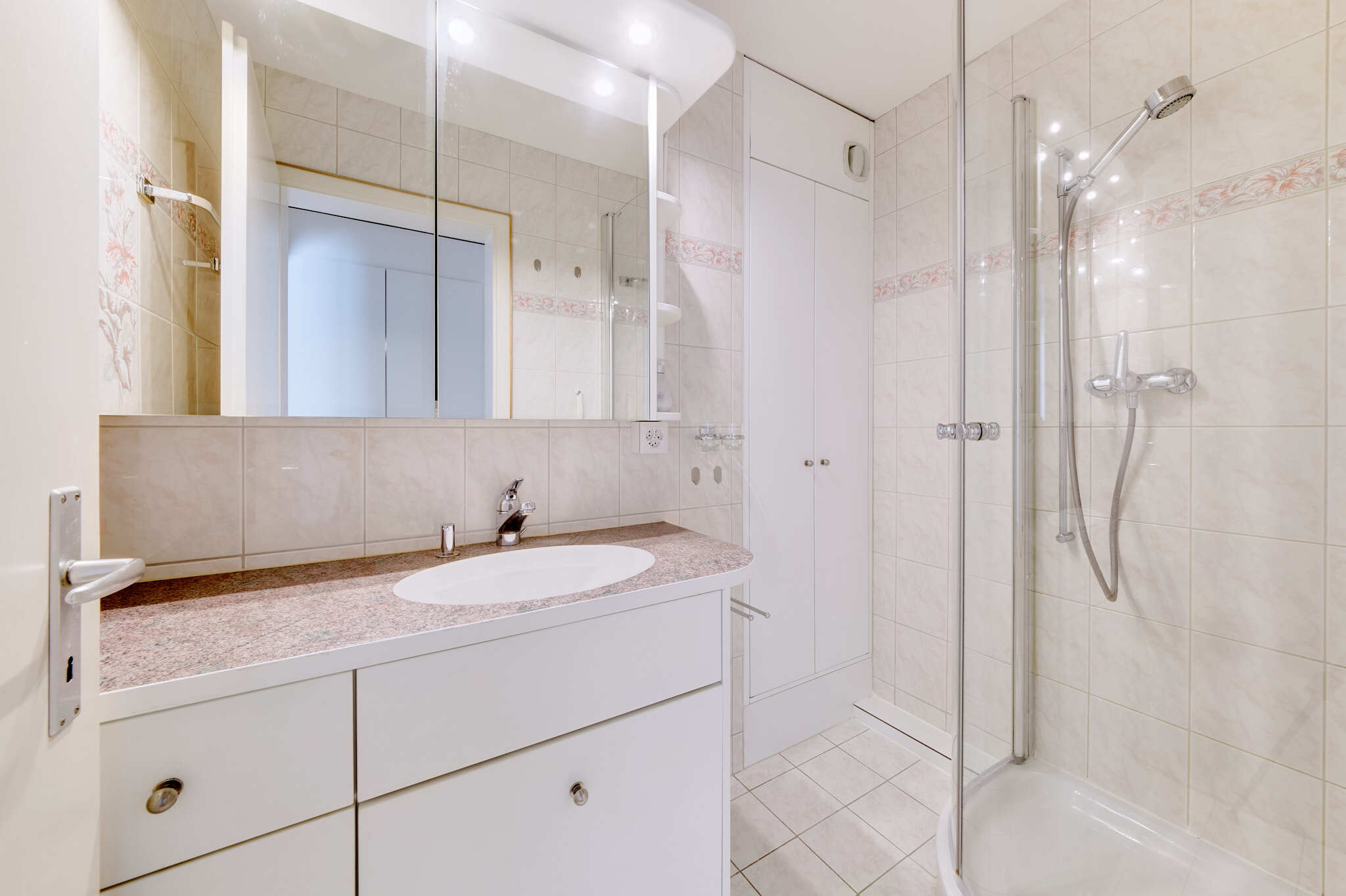 Badezimmer mit Dusche, Lavabo und Wandschrank