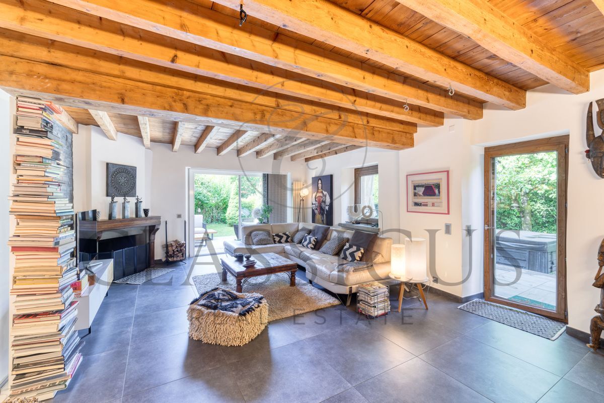Salon avec cheminée et poutres apparentes en bois.