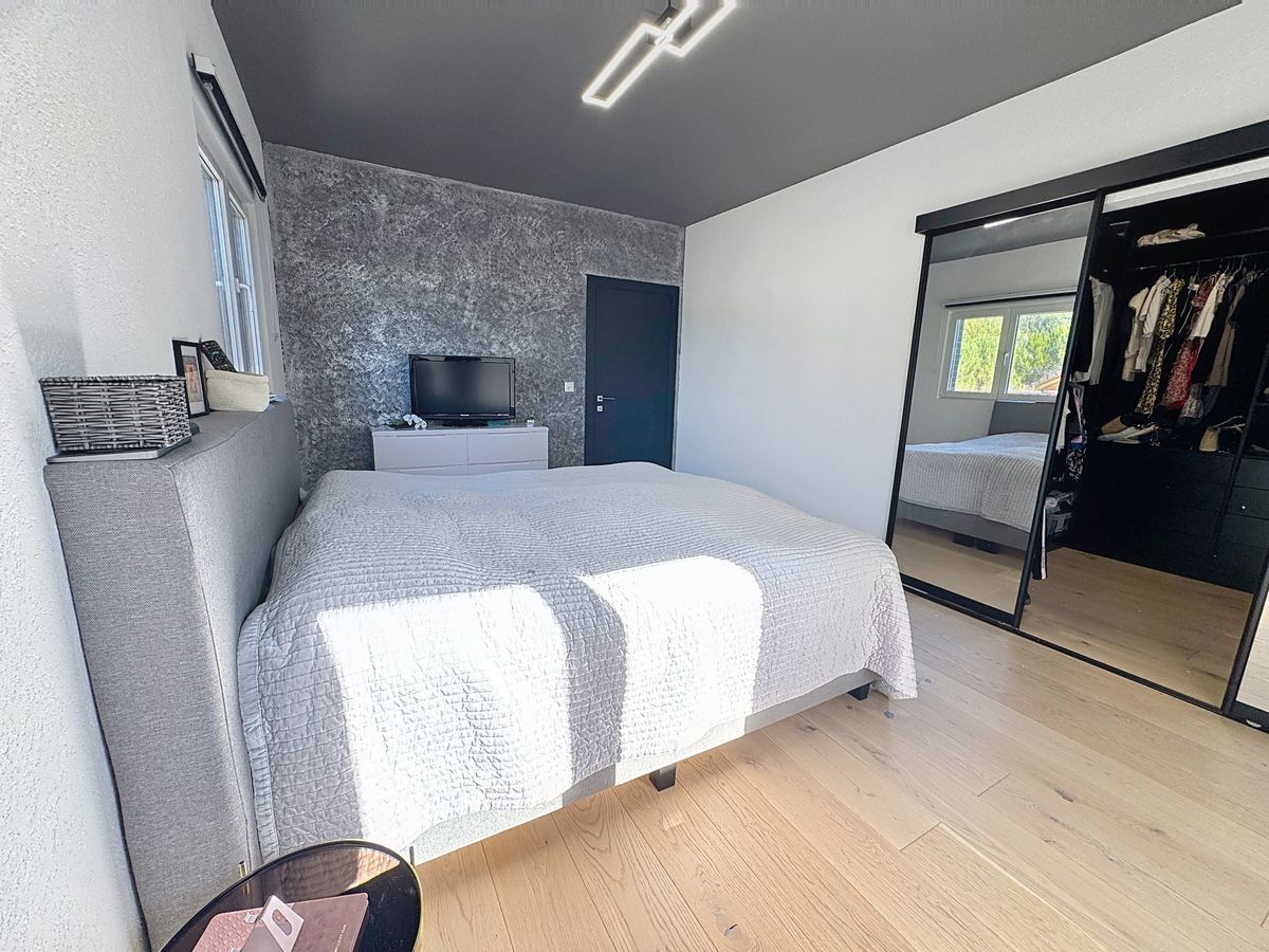 Chambre avec lit double, armoire miroir et TV.