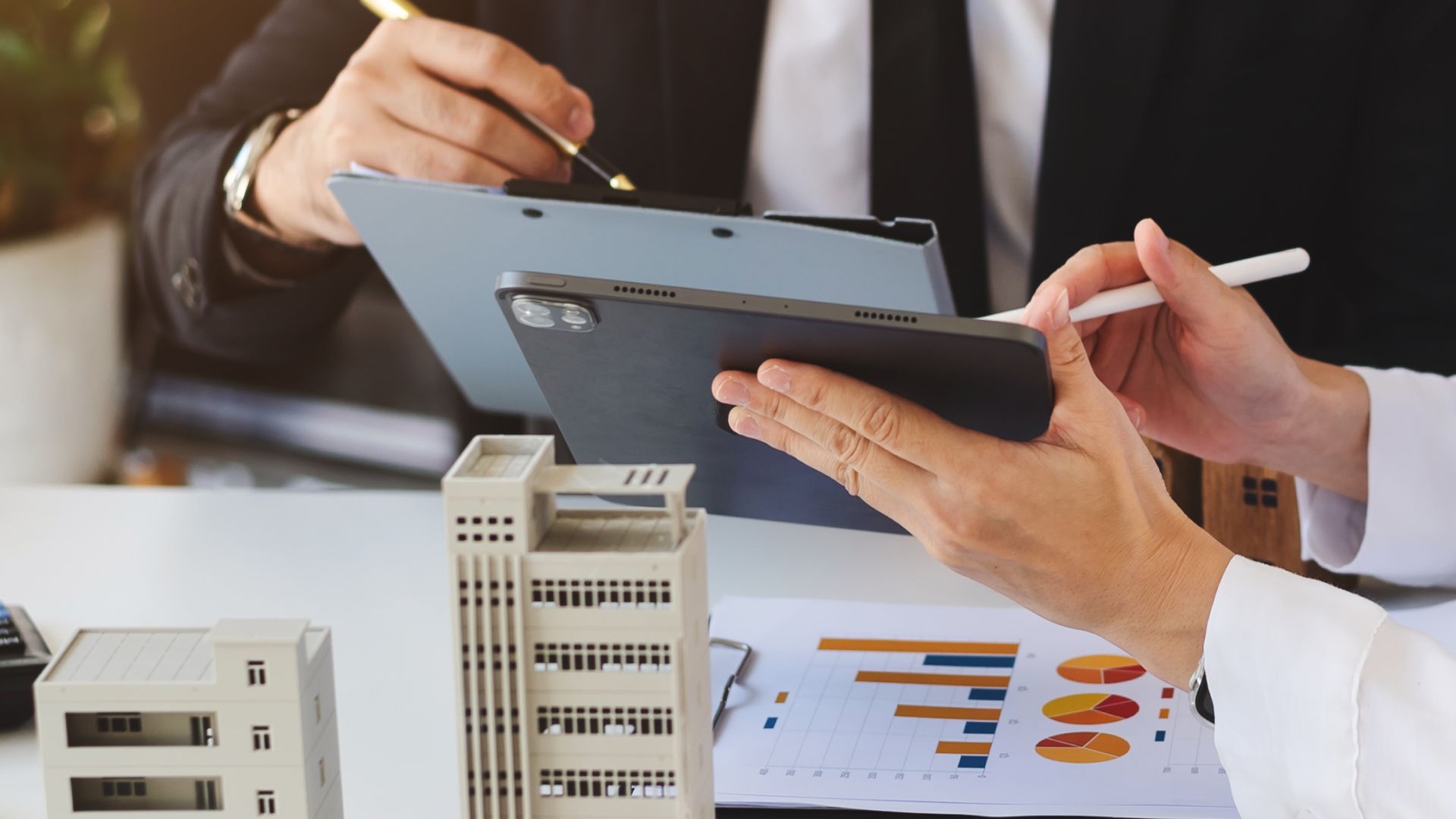 Real estate professionals using tablets to search and compare properties based on usable floor area.