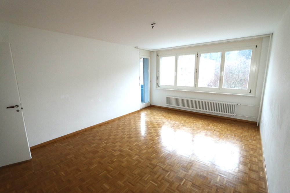 Helles Wohnzimmer mit Ausgang auf den sonnigen Balkon.