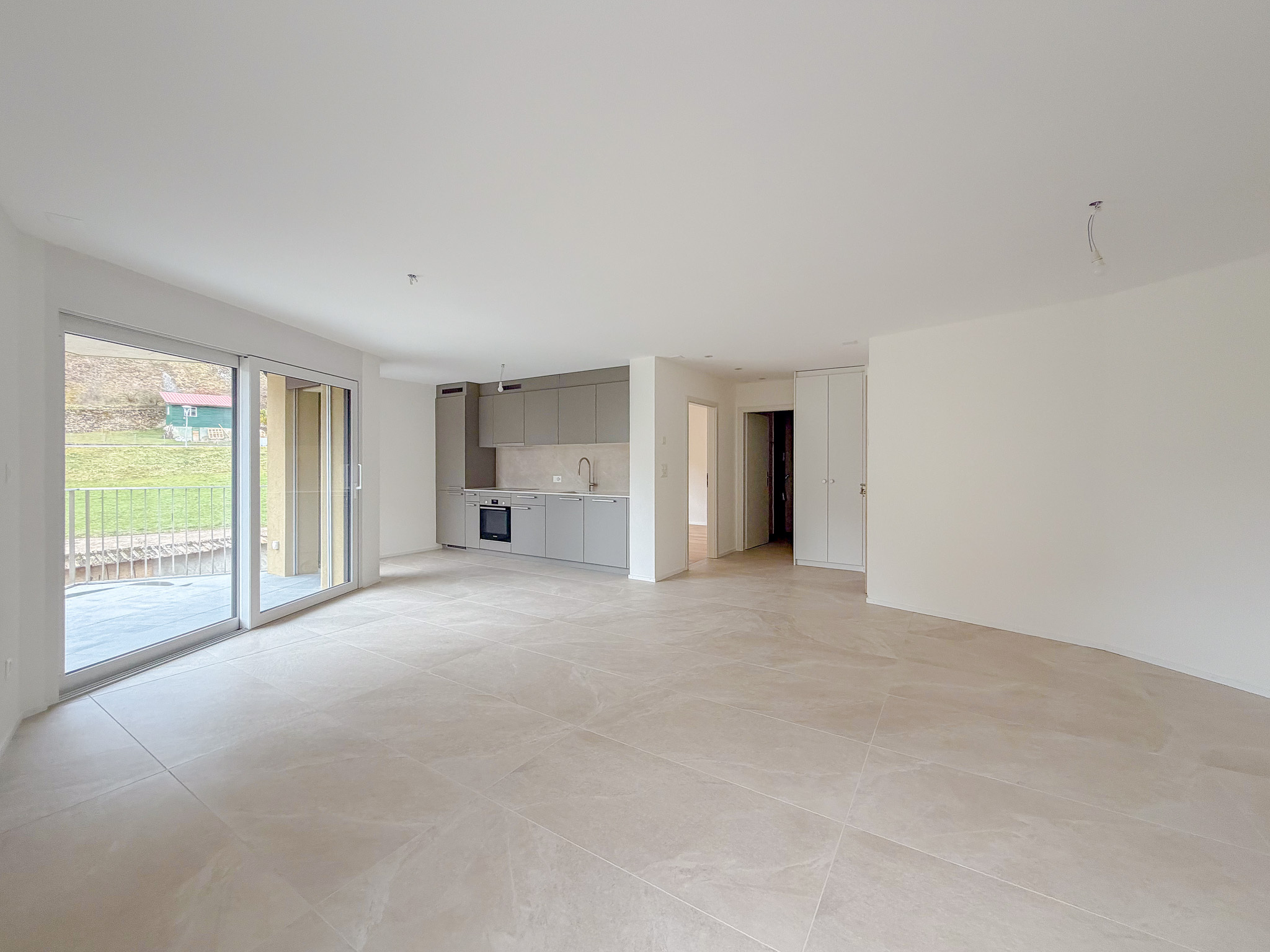 Espace salon/séjour avec portes-fenêtres donnant accès au balcon