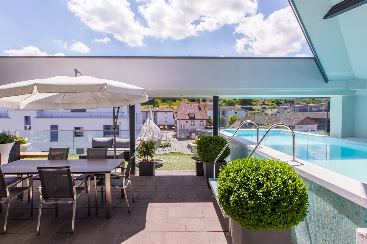 Teilgedeckte Loggia mit Swimmingpool.