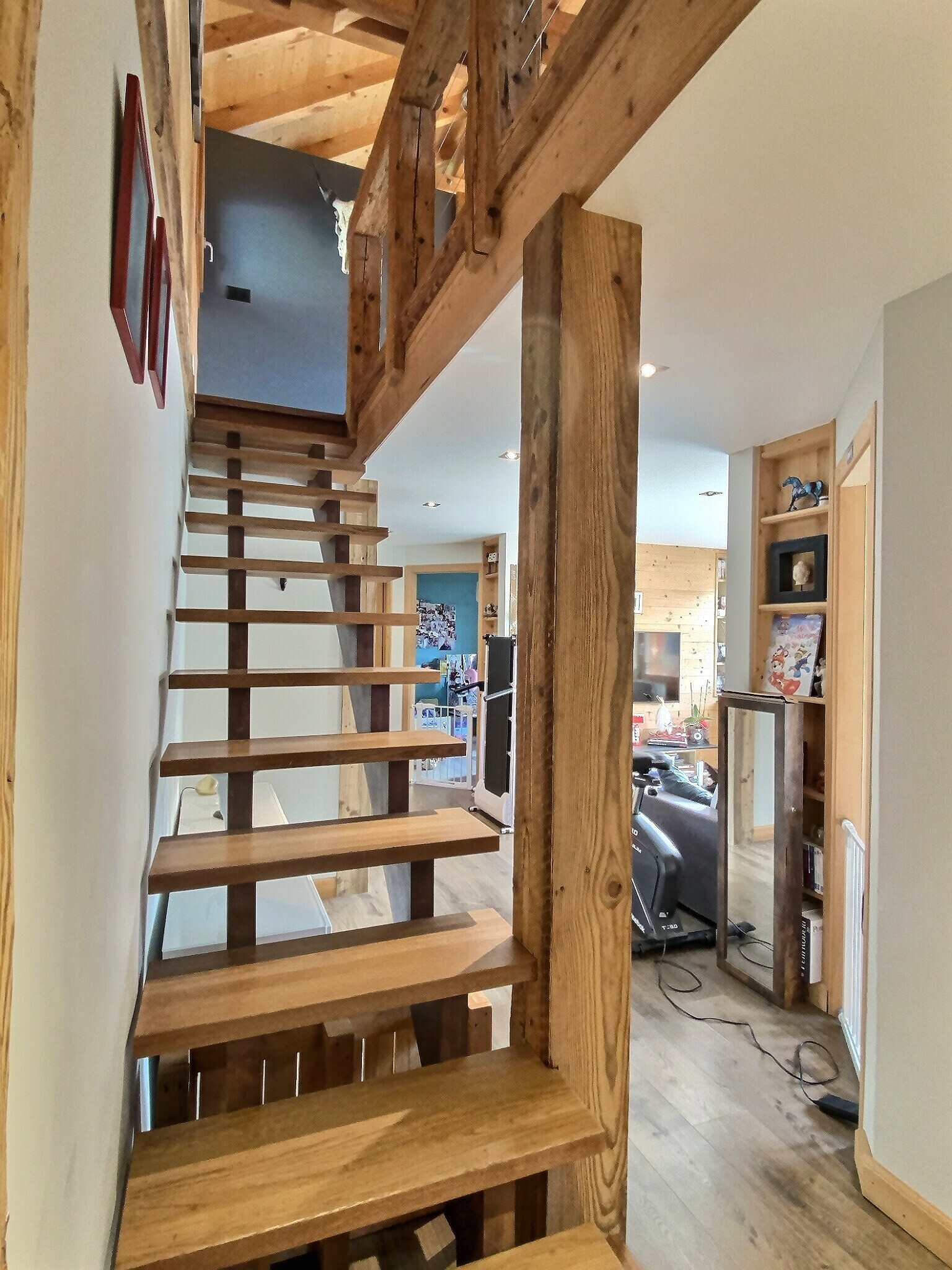 un escalier en bois mène au deuxième étage de cette maison