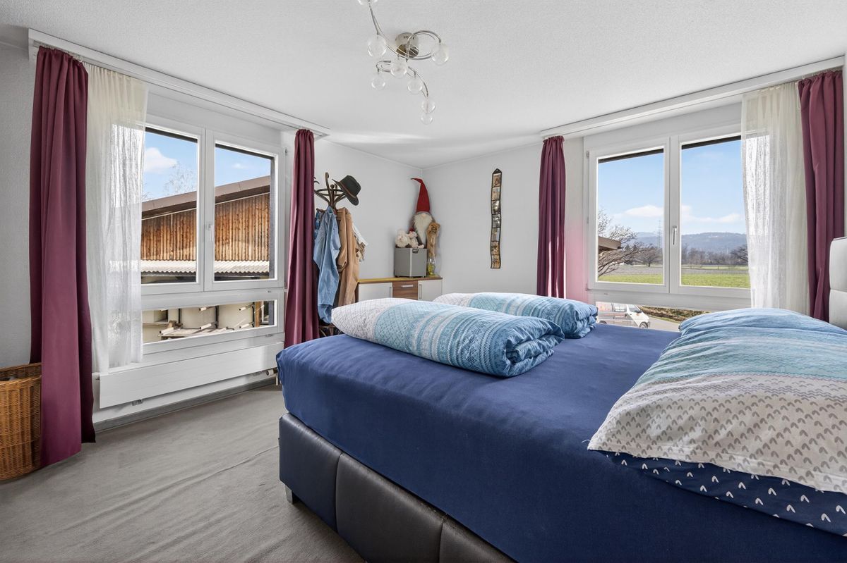 Helles Schlafzimmer mit mehreren Fenstern und Bergsicht. Helles Schlafzimmer mit mehreren Fenstern und Bergsicht.