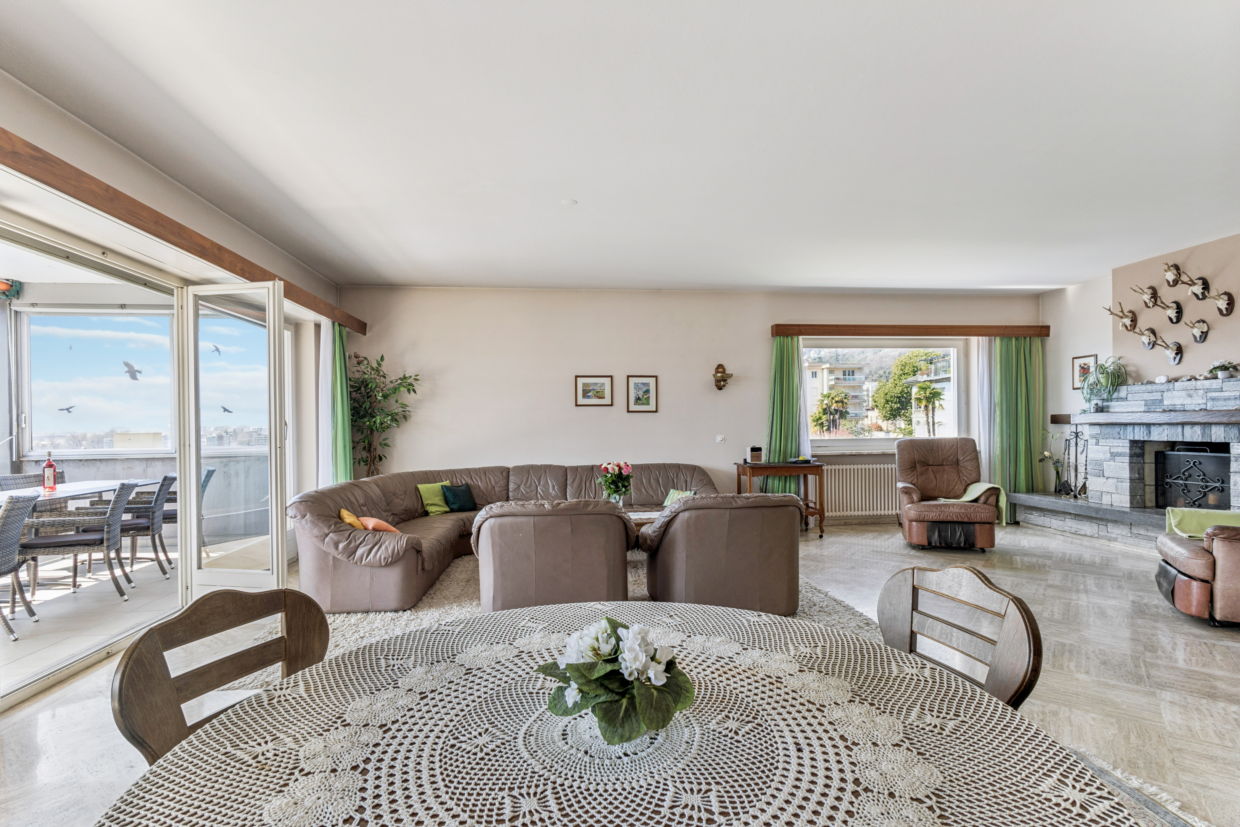 Soggiorno e zona pranzo con porte-finestre sull'ampia terrazza coperta